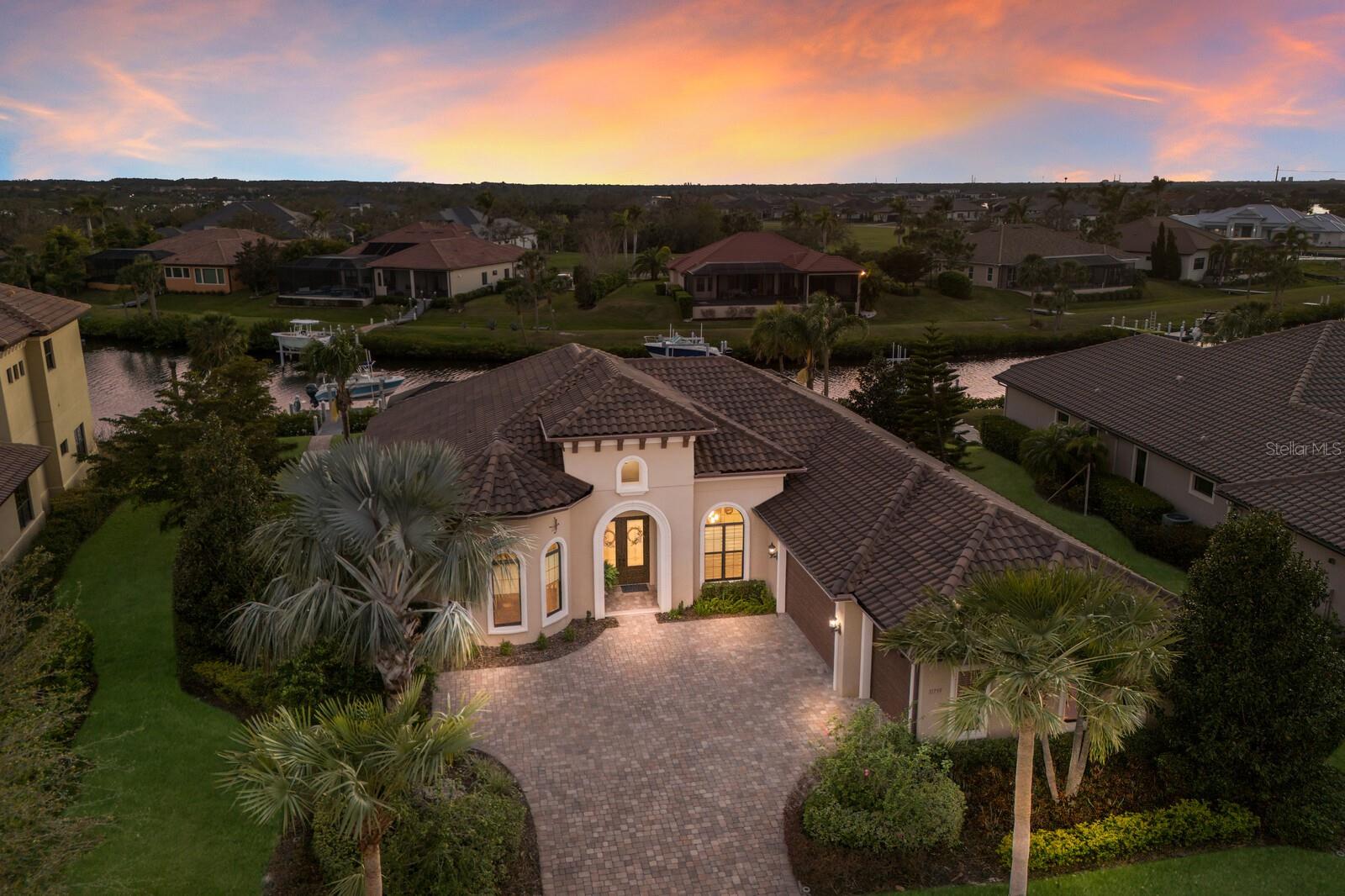 EXCLUSIVE BOATING & GOLF PARADISE: LUXURY HOME WITH PRIVATE DOCK AND DIRECT RIVER ACCESS IN A PREMIER COMMUNITY NEAR LAKEWOOD RANCH, SARASOTA, AND ST. PETE. This stunning home, built by renowned luxury home builder Arthur Rutenberg, showcases the Coquina model, perfectly designed for both elegance and functionality. Located on a harbor with direct access to the Manatee River, which flows to the Gulf of Mexico, the home is complete with a private TREX dock featuring a 10,000-pound lift, water, electricity, and a safety light. The home features a highly sought-after open floor plan, seamlessly connecting a chef’s kitchen, dining room, breakfast nook, and great room. The split floor plan offers a luxurious primary suite with dual walk-in closets, a spa-inspired bathroom, and a private room with breathtaking water views, while two private guest bedrooms each have their own bathrooms. The property includes a 3-car side-entry garage, an oversized den/office with a beautiful round ceiling, crown molding, and hardwood floors. High-end finishes like porcelain tile throughout, recessed lighting, and decorative niches enhance the home's sophistication. Additionally, roll down storm shutters along the back of the home and hurricane impact-resistant windows throughout provide peace of mind. Sunsets will wow you from the oversized lanai with summer kitchen and tons of seating areas. Additional luxury features include built-in dehumidifier in the garage, hot water circulating pump, and security system. The community, The Islands on the Manatee River at River Wilderness, is a haven of privacy and indulgence, offering amenities such as 24-hour manned guard gates, a community boat ramp, bocce ball courts, and an exclusive River Club with private fitness rooms, social events, and more. Residents may enjoy optional membership opportunities at The Club at River Wilderness with access to year-round golf, pickleball, tennis, and fitness center amenities/exercise – or benefit from resident/guest options at the restaurant and pay-as-you-play golf opportunities. Conveniently located off Ft. Hamer Rd, access is quick to the Ft. Hamer bridge connecting you to Bradenton and Lakewood Ranch via SR64 and Lakewood Ranch Blvd. Enjoy a variety of nearby shopping centers and restaurants in Bradenton and Parrish. The community is best known for its central location to St. Pete, Bradenton and Sarasota.