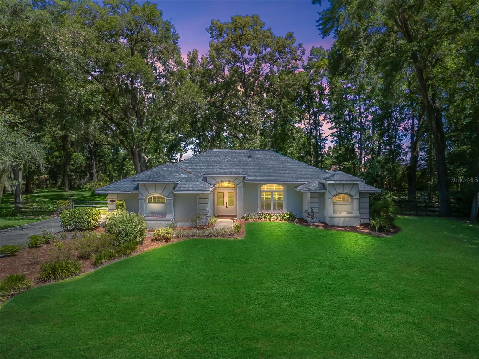 One or more photo(s) has been virtually staged. Privately situated in the coveted community of Summit Downs, this private 1.23 acre property offers a spacious 4/2 home with numerous enhancements and updates. Stately curb appeal with mature landscaping and side entry 2 car garage welcomes you home. The new double leaded glass front door leads inside where you will find LVP floors throughout, soaring vaulted ceilings and more. The open kitchen boasts gorgeous stone countertops, light cabinetry, tiled backsplash, closet pantry, reverse osmosis tap, and stainless steel 5 burner gas range with hood. You will also appreciate skylights, a solar tube, beautiful fixtures & fans, and more. The split bedroom layout offers a spacious primary suite with access to the lanai, plus a walk-in closet with built-in system and an ensuite bathroom with granite countertops, vessel sink, beautifully tiled walk-in shower and separate water closet. On the opposite side of the home are 3 additional bedrooms with a shared bathroom with a long vanity and shower/tub combo. The covered and screened lanai leads to the huge 59' x 38' birdcage which would be a great pet area, playground or garden - plus a decorative Koi pond. The spacious yard is completely fenced with a large gate leading from the driveway and separately fenced area for a garden. Updates and enhancements include: new roof in 2021, new double pane windows in 2020, new AC 2019, water heater 2018, new front door in 2023, and top-of-the-line security camera system. All this property needs is you! Located in the gated community of Summit Downs, which is accessible through the equestrian community of Ocala Downs - just 20 mins to Downtown Ocala and 30 mins to The WEC. Please enjoy the attached 3D & video tours!