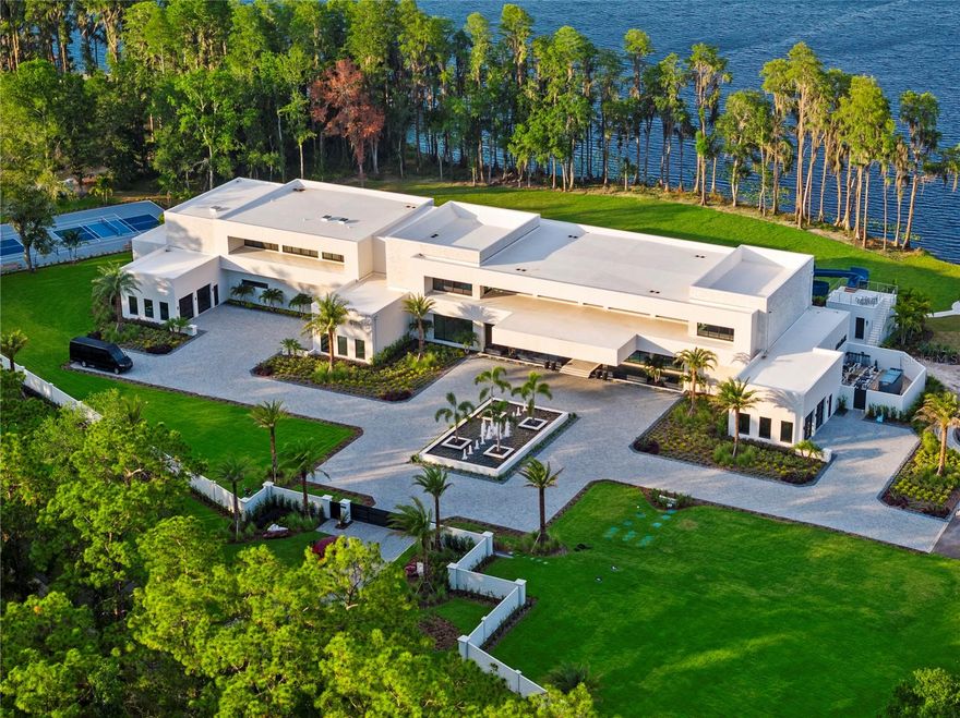Welcome to a truly one-of-a-kind, ultra-luxurious estate that embodies the pinnacle of modern design and sustainable living. This newly built (2024), resort-style masterpiece by renowned architect Phil Kean showcases unparalleled craftsmanship and meticulous attention to detail, with no expense spared in every aspect of the home. This architectural sanctuary is set on a breathtaking nearly 5-acre lakefront homesite with expansive views of the private Island Ford Lake. The show-stopping multi-million dollar infinity pool, designed by Ryan Hughes and featured on the cover of Luxury Pool & Outdoor Living Magazine, is just the beginning. With a tennis court, pickleball court, and dock equipped with boat and jet ski lifts, this estate offers a true waterfront lifestyle. The covered lanai is nearly 4200 SF alone and features an automatic remote screen and full outdoor pool bath. Inside, you’ll discover an impressive movie theater, with a state-of-the-art sound system, captivating audio-visual, and lighting features throughout the home. The main residence boasts expansive living areas, 5 bedrooms, 7 bathrooms, and over 16,000 SF of living space, with a total of over 23,000 SF. The estate's total includes 6 bedrooms, 10 bathrooms, and features a total of 6-car garage bays with high ceilings, allowing for car lifts. Guests will enjoy a luxurious ADA-accessible 1-bedroom, 1.5-bath guest house, while the charming lake house cabin includes a full kitchen, bath, and screened porch for relaxing after a day on the water. For wellness and relaxation, the estate offers a state-of-the-art sauna room, a tranquil massage room, and a fully equipped fitness center, ensuring every need for rejuvenation and physical well-being is met. This home is enhanced with world-renowned Alex Turco art, which wraps the inside and outside bar as well as the pool water feature. The estate is fully enclosed by a stone wall for ultimate privacy and security, with gate access featuring facial recognition at the main entry and a separate service entrance. With too many features to list, this sanctuary offers the tranquility of lakeside living, just moments away from the vibrant Tampa Bay area.