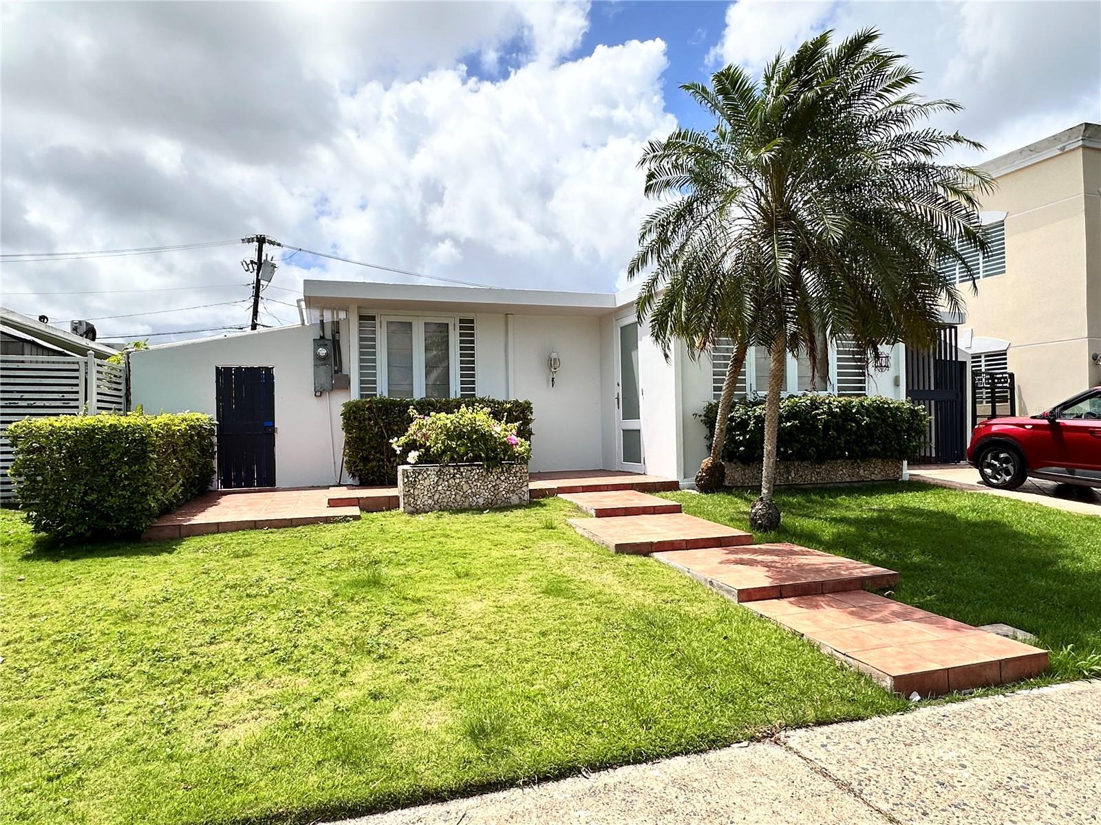Spacious One-Level Home for Rent in Gated Community – Parkville East, Guaynabo
Located in the highly sought-after Parkville East neighborhood, this spacious single-family home offers comfort, convenience, and security. Parkville East is a gated community with controlled access, offering peace of mind and easy access to main roads, shopping, schools, and more.
This one-level residence features 3 bedrooms and 2.5 bathrooms, including a master suite with a private bathroom and walk-in closet. All bedrooms as well as the living room are equipped with individual A/C units for year-round comfort.
Enjoy a generously sized living and dining area, perfect for entertaining or family gatherings, as well as a large kitchen with ample cabinet and counter space. Kitchen appliances included: stove, microwave, and refrigerator. The garage accommodates two vehicles parked one behind the other.
Step outside to a covered terrace and patio area, ideal for outdoor dining or relaxing. Additional features include a laundry space with washer and water heater.
Don’t miss the opportunity to live in a secure and centrally located community in Guaynabo!