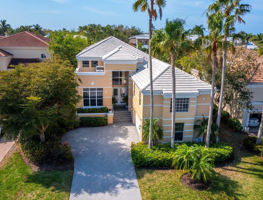 Indulge in the pinnacle of opulent Longboat Key waterfront living in sought-after Queens Harbor, an intimate established community behind the gates of Bay Isles. Behold the impressive 2-story façade upon approaching the stately paver drive, enveloped by lush landscaping to create a shaded, verdant tropical setting. With 3,957+/- sprawling sq. ft. of living area, this exceptional residence offers a harmonious blend of luxury, comfort and timeless elegance. Step inside and be greeted by a grand entrance, where natural light beams through an abundance of windows, illuminating the splendid neutral tones, the exquisite details of the interior and the striking, curved staircase at your doorstep. The open floor plan seamlessly connects the living spaces, allowing an inviting ambiance perfect for both family living and entertaining guests at any scope. Whether you're preparing a family meal or hosting a soirée, the spacious gourmet kitchen is sure to impress, featuring all-white cabinetry and matching top-quality appliances, ample counter space, a breakfast bar and an adjacent dining area offering a picturesque setting for enjoying meals. Retreat to the sumptuous primary suite, a haven of privacy and relaxation on the first floor, complete with a spa-like en suite bathroom, walk-in closets and a sitting area. Additional bedrooms and bathrooms are thoughtfully designed to provide comfortable and private accommodations. Multiple sliders lead to the expansive patio, which boasts an open pool, lush landscaping, room for outdoor gatherings and a quaint walkway to your private dock and easy access to the Bay.  Bay Isles offers deeded beach access, tennis, beach club and more. Longboat Key Golf & Tennis Country Club membership are available.