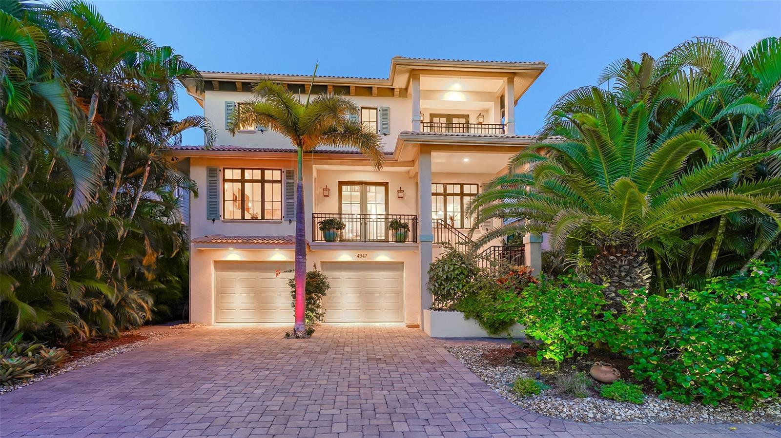 This 4 bedroom, 4.5 bathroom home is the perfect place to vacation where you live. Situated on Siesta Key, this West Indies style home is a tropical retreat; and, with four en-suite bedrooms, is large enough for you and your guests. The main level boasts a soaring foyer. As you enter you will be delighted by the warmth of the refinished hard wood floor, and the light space that welcomes you home. The living room features a high ceiling, a dual sided ceiling fan and high windows flooding the room with filtered sunshine. The cozy gas fireplace makes this the perfect spot to gather with friends on a lovely cool Florida evening. The formal dining room has tray ceilings. The spacious center Island gourmet kitchen, with new gas cooktop, features slab granite counters, stainless appliances, wine cooler and a chef’s desk. Walk upstairs or take the elevator to the master suite. This space, with three walk-in closets, a wet bar, and balcony overlooking the lush back yard is a tranquil sanctuary. Imagine retreating here after a day on the world-renowned Siesta Key Beach. Luxuriate and recharge in the master bath with granite, travertine, 7 head shower, and soaking tub. Step outside and you will find the outdoors are as compelling as the inside. Beautifully designed with a large, heated swim-spa, this is the perfect place to end another gorgeous day in Paradise. Meticulously maintained, and built to high standards, this home has impact windows all around, a full house fire extinguishing system and top of the line finishes. The oversized garage has room for 2-3 cars, a work area, and offers plenty of storage. Located just minutes from the beach, the proximity to downtown Sarasota makes it easy to take advantage of all the dining, shopping, cultural and recreational offerings of the area. This unique home is an incredible find for those who want to live a distinguished Gulf Coast lifestyle!