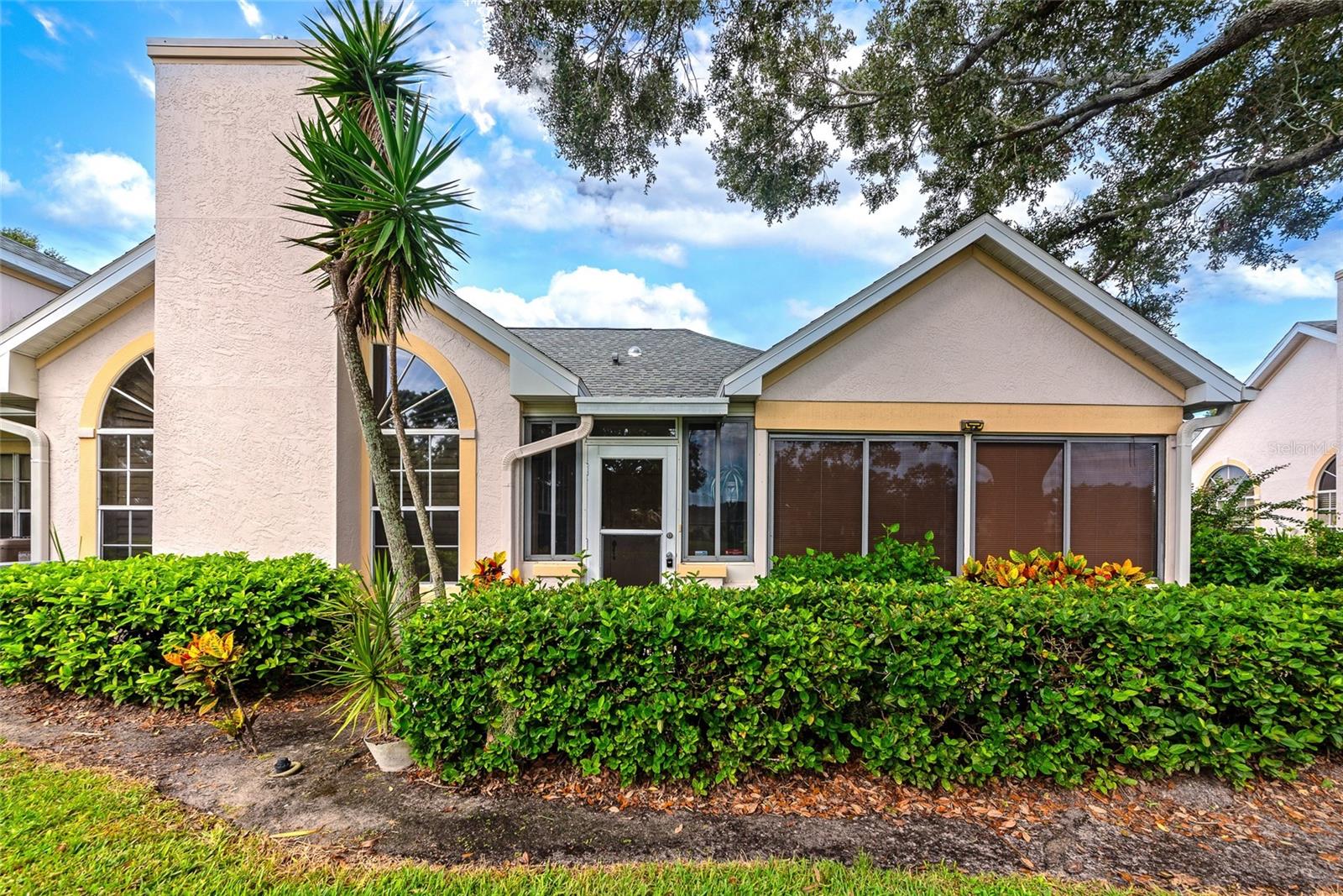 Come see this incredible 2 bedroom, 2 bathroom condo located in the highly sought-after community of Calumet at Centergate! Perfectly positioned in a peaceful, tropical setting, this residence offers comfort, style, and low-maintenance living just minutes from Sarasota’s best beaches, shopping, and dining. From the moment you arrive, you’ll appreciate the lush landscaping and spacious one-car garage. A charming enclosed front porch welcomes you, an ideal spot for morning coffee, indoor gardening, or simply relaxing while enjoying tranquil pond views. Inside, soaring ceilings and arched windows fill the home with natural light, framing the cozy wood-burning fireplace in the main living area. Easy-to-maintain tile flooring runs throughout the living spaces, complementing the airy, open layout. The fully equipped kitchen offers abundant cabinetry, matching appliances, granite countertops, a stylish tile backsplash, a dining nook, a built-in breakfast bar, and a big pantry closet for extra storage. The primary suite is a serene retreat, featuring vaulted ceilings, a generous walk-in closet, and an en-suite bathroom with a large vanity, private water closet, and a spa-like walk-in shower. The second bedroom, also with high ceilings, enjoys its own separate entrance to the Florida room, making it ideal for guests or as a versatile home office. A full guest bathroom with a tub/shower combination completes the layout. At the rear of the home, the fully enclosed Florida room offers wall-to-wall windows and tile flooring, perfect as a sunny reading nook, an indoor plant paradise, or a peaceful workspace with relaxing views. Living in Calumet at Centergate means enjoying the best in maintenance-free living, along with access to a beautiful clubhouse, fitness center, and sparkling community pool. With popular shops, restaurants, commuter routes, and Gulf beaches just minutes away, this home truly combines convenience with comfort and everything Florida is all about. Do not wait, call today to learn more and schedule your showing!