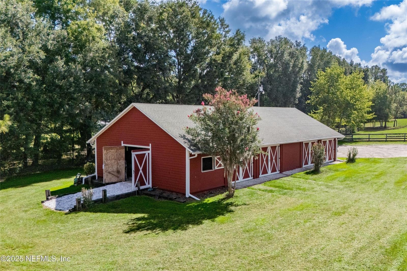 A Rare Offering of Timeless Beauty and Unmatched Setting - Welcome to what may be the most spectacular property on the market today! A stunning custom home set on just over 5 acres of peaceful countryside, just minutes from the heart of Alachua. With breathtaking views of rolling farmland in every direction, this is where elegance meets serenity. From the moment you arrive, the charm of this two-story Southern-style home will capture your heart. Expansive porches stretch across the entire front of both levels, inviting you to slow down and savor the views. Inside, the home is filled with natural light and designed for both comfort and entertaining. The spacious owners suite is a true retreat, featuring a cozy sitting area surrounded by built-in bookshelves, the perfect spot to unwind. The luxurious en suite bath offers separate his-and-her closets, a freestanding tub, and a walk-in shower. The open and airy floor plan continues with a sunroom warmed by a gas fireplace,
a screened back patio ideal for enjoying quiet mornings, and a large laundry room with bonus space that could serve as a home gym, craft room, or additional storage. Upstairs you'll find three bedrooms and two full baths, including a Jack-and-Jill, plus a flexible bonus area - perfect as a second living room, playroom, or home office. Outside, the property is fenced with attractive 4-board fencing, perfect for animals and adding classic country appeal. A jasmine-covered sitting area provides a front-row seat to the most breathtaking sunsets. The 2,300 sq ft barn, once a 10-stall horse barn, has been thoughtfully converted to garage and storage space but could easily be returned to its original purpose or adapted for your needs, plus a three person sauna perfect for unwinding. This is more than a home, it's a lifestyle. A rare chance to own a property where every detail invites you to relax and enjoy the best of country living, all within easy reach of shopping, dining, and top-rated schools.