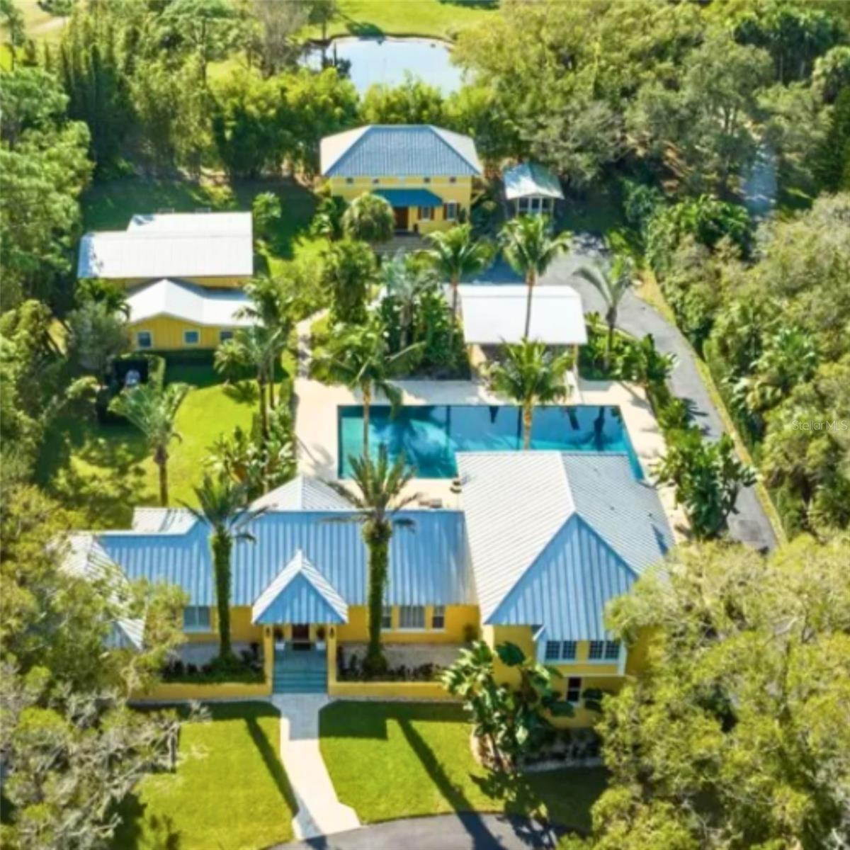 On 2.35 acres of meticulous grounds, this rare Anglo-Caribbean gated compound offers security, privacy & beauty. The prop is comprised of a 4/4.5 primary home, 2/2 guest house (w kitchen + living), flex building w a gym, office & studio, generator, limestone patio, summer kitchen, chicken coop, garden beds, 200’ artesian well w/ irrigation, RV/boat parking w/ electricity & an Olympic saltwater pool --one of the largest in town! CBS, 10' ceilings, primary dwnstairs, impact rated flex space, metal roof, double insul & more! Close to town yet self-sustaining. Old FL living that can't be matched!