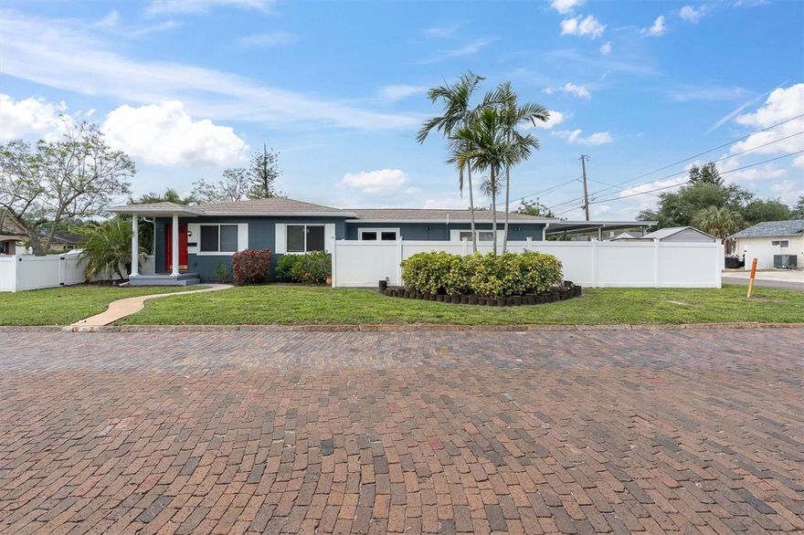 One or more photo(s) has been virtually staged. Beautifully updated 3/2 mid-century modern home in highly desirable Lake Pasadena Estates on a corner lot. Split bedroom floor plan with beautiful original hardwood floors in the living room and 2nd and 3rd bedrooms.  The living room is complete with crown molding, chair rail, and French doors.  The French doors lead out to the spacious side yard with a large deck, newer vinyl fencing, brand new St. Augustine sod, and mature landscaping. This is a great, peaceful area to enjoy with plenty of room for dogs and to entertain.   A completely remodeled kitchen with custom cabinets, cabinet underlighting, dimming lights, granite countertops, a kitchen island, and stainless-steel appliances. The kitchen also features a rare and extremely helpful 3 sink basin. There is additional room to eat in the kitchen. The kitchen opens up to a formal dining room with room for a large dining room table.  Kitchen and dining room floors are wood-looking porcelain tile flooring. The dining room is connected to a family room/den.  It was perfectly utilized as an office area, but is a multi- purpose space for whatever need you have, small gym, 2nd living room space. The dining room also leads out to a very large patio area with lighting and 2 sheds for storage.  This is a great space to grill, entertain with family and friends, with 6 foot privacy vinyl fencing.  The Interior laundry room is spacious with a built- in closet and plenty of room for stackable storage.  The primary suite is large with luxury vinyl flooring and his and her separate closets. Other recent updating includes New AC 2025, main roof 2019 and smaller roof 2025, water heater 2020. Newer gutters and downspouts 2020. There is an irrigation on a pump and a well that helps keep your landscaping having great curb appeal year round. Alley access leads up to a 2 car carport, which is very helpful in the hotter months and provides protection for your vehicles.  This home is nestled between two beautiful lakes in Lake Pasadena and Lake Disston. A truly great area for walking, bike riding, feeding the ducks by the lake and enjoying nature. Bear Creek Park is around the corner to enjoy activities and a newly constructed kids’ park. The perfect location in Central St. Pete providing easy access to St. Pete Beach, Treasure Island and vibrant downtown St. Pete within 10 minutes. Enjoy the best of both worlds with this location and don’t be tied down to one area to frequent.  Gulfport and the art district, along with their shops and restaurants, are also just minutes away. The surrounding area is filled with shopping, restaurants and professional services. No Flood insurance required with no damage from the storms or any flooding in the area.