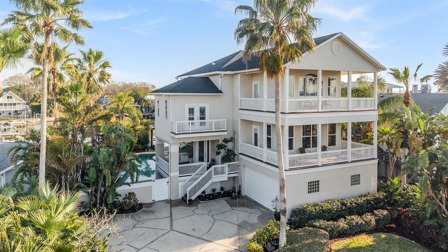 The ultimate in waterfront living awaits you in this Key West style pool home on prestigious Indian Bluff Island. Brand New Roof!!!!! Updated Kitchen and beautiful leathered stone counter tops. With an open and yet warm presence, the floor plan in this beautiful three story home with elevator, wood floors, vaulted ceilings and architectural detail has the feel of casual sophistication. There are multiple balconies, French doors and large screened porch off family room to enjoy the ever changing water views, sunsets and Gulf breezes. The private backyard offers dock, covered boat lift, davits, seawall and direct Gulf access from a protected cove. Bring your boat and all your water toys. The deep water channel will take you out to St. Joseph Sound.  Entertain poolside around the 25 meter lap pool in complete privacy surrounded by lush tropical landscaping and covered patio with beautiful pavers.  Downstairs Bonus room, Game room or In law Suite with an outdoor entrance and  a pool bathroom. Plenty of parking with the oversized garage and guest parking.  There are many more surprises to be found when you view this unique property located in a tropical and secluded location close to beaches, Pinellas Trail, Wall Springs Park, schools and shopping. Live the Island lifestyle and vacation at home everyday