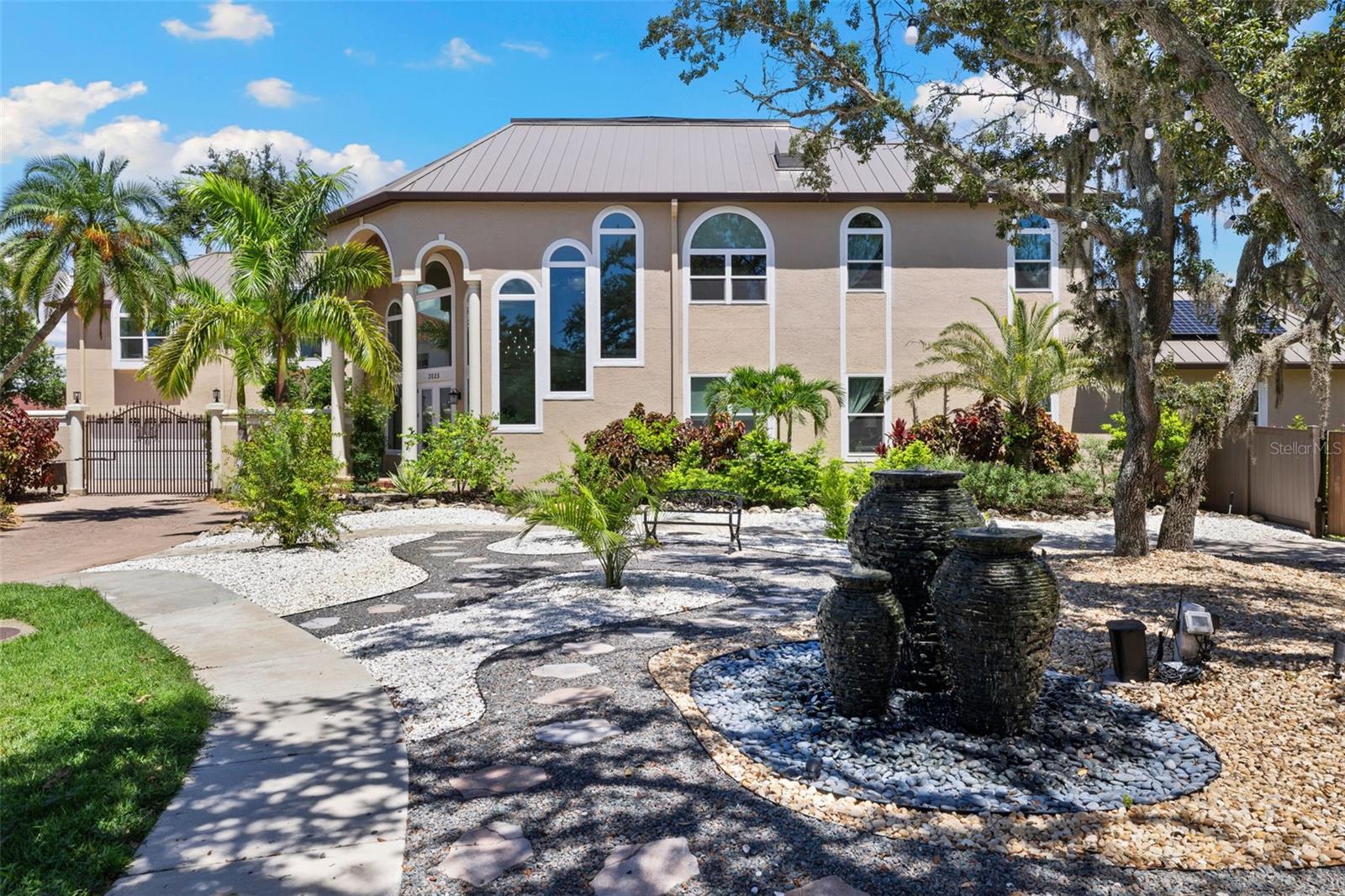 Price Improvement 100K Aug. 21st! Where luxury meets paradise—with a jaw-dropping backyard oasis and WELL over $1 million in UPGRADES since 2022, this exceptional estate offers a rare blend of resort-style living, energy independence, and multigenerational flexibility. Built for those who expect more, this home is tucked inside the exclusive 11-home gated enclave of Landmark Reserve on 1.11 high-and-dry acres at the end of a quiet cul-de-sac. Designed for privacy, security, and sustainability, it features a top-of-the-line bronze Galvalume standing seam metal roof (2022), fully paid 40.8 kW solar system with 125 SunPower panels, five HVAC systems (2022), and PGT hurricane-rated impact windows and garage doors ($350K upgrade in 2023). Energy bills average just $35/month, supported by a Level 2 EV charger, water softener, and private well with irrigation. The sweeping gated driveway leads to a four-car garage and sets the tone for this one-of-a-kind property. Inside, luxury finishes include rich hardwood and marble tile flooring, coffered ceilings, custom millwork, and a grand imperial staircase beneath a statement crystal chandelier. The gourmet kitchen is a chef’s dream, with a Wolf 6-burner gas cooktop, over Wolf convection ovens, Sub-Zero refrigerator (2023), oversized island, granite counters, and custom cabinetry. The main-floor primary suite is a spa-like retreat with a frameless walk-in shower, over rain shower heads, soaking tub, double vanity, and direct access to the outdoor living area. A fully renovated guest apartment (2023) with private entrance includes its own kitchen, breakfast nook, living space, and laundry—ideal for guests, in-laws, or live-in support. The oversized family room with stone fireplace and pool views offers perfect space for a game room or secondary lounge. Outside, the tropical resort setting stuns with a saltwater heated pool and spa, travertine decking, sun shelf, LED lighting, elegant water features, boulder rock fountain, and a tranquil pond with a color-changing fountain (maintained by the HOA for chemical and algae control). The covered outdoor kitchen is fully equipped with natural stone bar, gas grill, wet bar, built-in seating, and a private pool bath. An adjacent lot is included and offers the potential for an additional garage, structure, or even resale for a minimum 5,000 sq ft home. Whether you're entertaining dozens or enjoying peaceful sunset evenings, this property delivers an unmatched Florida lifestyle. Minutes to Clearwater Beach, Safety Harbor, Dunedin, airports, shopping, and fine dining. A rare opportunity for a buyer who values true craftsmanship, modern systems, energy efficiency, and turn-key luxury in a private estate setting. Don’t miss this rare opportunity. Be sure to check out the stunning home tour video: https://properties.premiermediag.com/videos/01986169-6fde-7135-bfa0-c520d7d46ddd