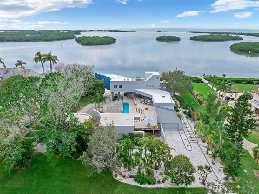 Enjoy modern coastal living on your own private waterfront beach with exquisite, unobstructed open water views of the Gulf of Mexico. Situated on nearly an acre with the prestigious Oceanview Drive address of Tierra Verde, this architecturally unique waterfront residence offers a wonderful opportunity to create your dream home in one of Tampa Bay’s most desirable locations. Built in 1988 with a forward-thinking open-concept design, the home features expansive floor-to-ceiling windows that blur the lines between indoors and out, offering panoramic views from nearly every room. White Oak hardwood floors span the main living areas, enhancing the warm, modern aesthetic. The upper-level primary suite present an exceptional opportunity for a redesign to your own specific vision - allowing you to fully personalize and elevate the living experience to today’s luxury standards. The flexible floor plan includes a loft-style second level with current drawings for a reconfiguration and expansion—add bedrooms, baths, or an entertaining 'sky deck' to suit your lifestyle. Outdoor living is just as impressive, with the rooftop deck and hot tub offering 360-degree views, a secluded private beach, expansive sun decks, lush landscaped gardens, and a detached guest retreat complete with its own personal gym. Located just 10 - 15 minutes from St. Pete Beach, Downtown St. Petersburg, Fort De Soto Park, and the I-275 corridor, this property combines privacy, potential, and prime waterfront access. Bring your vision and make this iconic Gulf-front property your own!