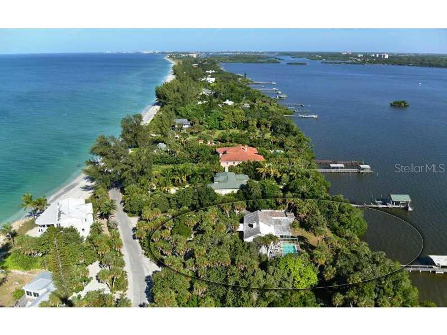 The list price includes two separate parcels.  Choose to build as two home sites with a home and separate garage on each or combine the parcels as one with a total Bay frontage of 200' and a homesite of over one acre. Owner has a Letter of Determination from Sarasota County.  Situated on one of the higher elevations available on Casey Key, the current home on one parcel is true Old Florida charm. Built in 1937, this bungalow design features Pecky Cypress wood in the living and dining room, along with two fireplaces in the living and owner's suite. Uniquely available, this home provides walk in attic space with a full cedar clothing closet. You will truly revel in the views to the Bay while in the home or pool area and enjoy the heavily landscaped privacy from your neighbors. The covered boat dock reaches out to provide an amazing view of the Bay, Black Burn Point Bridge and beyond. Take advantage of this rare opportunity of location, land size and flexibility, elevation, mature landscaping and views. It truly is a diamond in disguise waiting for your choice renovation or your own dream home.  Make sure you take the time to watch the aerial video virtual tour.  It allows you to appreciate this amazing opportunity!