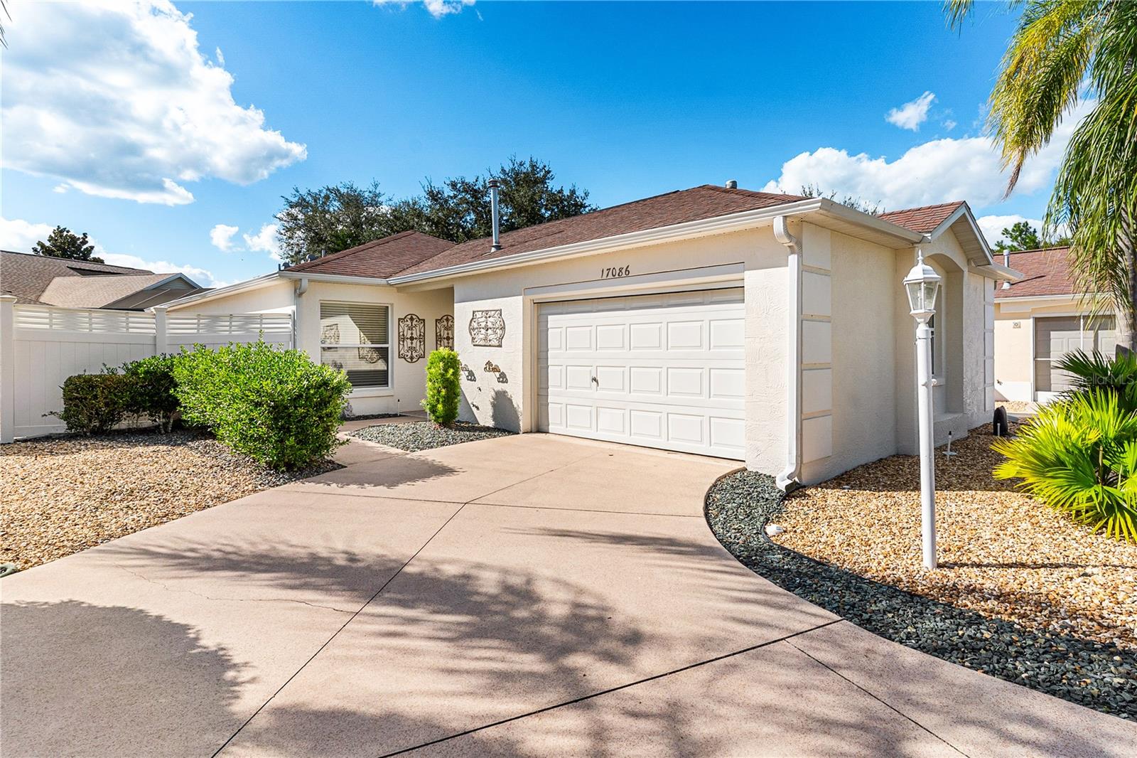 One or more photo(s) has been virtually staged. Welcome home! This stucco 2 bedroom, 2 bath courtyard villa with NO BOND is ready for its new owners. Featuring volume ceilings, an open floor plan, and no carpet, this home is easy to clean and maintain. Professionally painted in 2025, it’s move in ready and waiting for your personal touch. The spacious kitchen offers cabinets galore, pull-out shelves, and a large island with room for barstools, perfect for casual meals or entertaining friends. Not only does this home feature a glass enclosed Florida room, but it also includes a birdcage. Both are great spaces to relax, read a book, or enjoy your morning coffee or evening drink. The garage is equally impressive with epoxy flooring, a workshop area, and an automatic screen door, providing plenty of space for both a car and a golf cart. Outside, you’ll love the peaceful dead-end location and all rock landscaping, offering a clean, polished look with minimal maintenance. A transferable termite bond adds extra peace of mind.