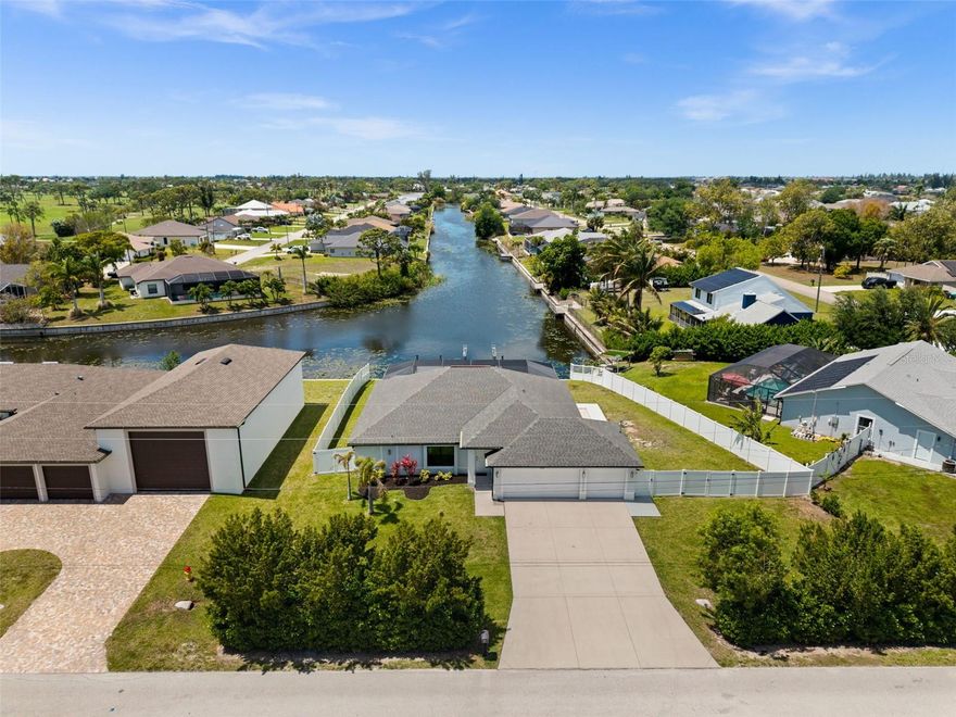 LONG WESTERN CANAL VIEWS on an INTERSECTING CANAL! 2020 BUILT HOME with CUSTOM, HEATED SALTWATER POOL, DOCK WITH BOAT LIFT, AIR-CONDITIONED 3-CAR GARAGE, and OVERSIZED LOT. Welcome to 1808 SW 8th Pl, a 4 BEDROOM, 2 bath waterfront home BUILT IN 2020 offering 1,718 sq ft of living space on a beautiful INTERSECTING FRESHWATER CANAL with spectacular long water views. Situated on an oversized lot of more than a quarter acre, this property offers an uncommon amount of outdoor space along with privacy created by a fully FENCED YARD and lush landscaping in front. WESTERN EXPOSURE provides incredible sunset views down the canal every evening. The outdoor living area is designed to take full advantage of the waterfront setting. The large SCREENED LANAI features a CUSTOM, HEATED SALTWATER POOL built in 2022 with a unique swim-up table, integrated umbrella stand, water features and tanning shelf, all overlooking the water views. The pool system is SMARTPHONE APP CONTROLLED, allowing you to easily manage heating, lighting, and pool features from anywhere. Just beyond the pool, the property includes a 40’ x 20’ DOCK WITH BOAT LIFT installed in 2022, offering excellent freshwater fishing for Peacock and Largemouth bass or easy access for kayaking and cruising the canal system. Inside, the home features tile flooring throughout, high ceilings, and an open split-bedroom floor plan. The kitchen offers granite countertops, stainless steel appliances, an island with breakfast bar, and a great view down the canal. The adjacent dining area includes sliding glass doors that open directly to the lanai and pool area, making indoor-outdoor living easy. The spacious primary suite enjoys water views and direct lanai access through sliding glass doors, along with two walk-in closets and an en-suite bath with dual sinks and a tiled shower. On the opposite side of the home, the 3 ADDITIONAL GUEST BEDROOMS are arranged for privacy, with 2 ADJOINING ROOMS that work well for guests or families. The guest bathroom also functions as a convenient POOL BATH. Additional features include a 3 CAR GARAGE WITH MINI-SPLIT A/C (2021), laundry room with washer and dryer, and a large FENCED SIDE YARD that provides excellent space for storage, equipment, or additional outdoor use. The home also includes SMART HOME FEATURES, with app-controlled pool equipment, smart door locks, and smart lighting that allow convenient control and monitoring from your phone. The pool and lanai were added in 2022, the dock and lift in 2022, and the fence in 2021. Located in the heart of SW Cape Coral, this home offers easy access to shopping, dining, schools, and parks while enjoying one of the best long canal views in the area. The property is NOT IN A FLOOD ZONE AND HAS NOT FLOODED IN ANY HURRICANE.