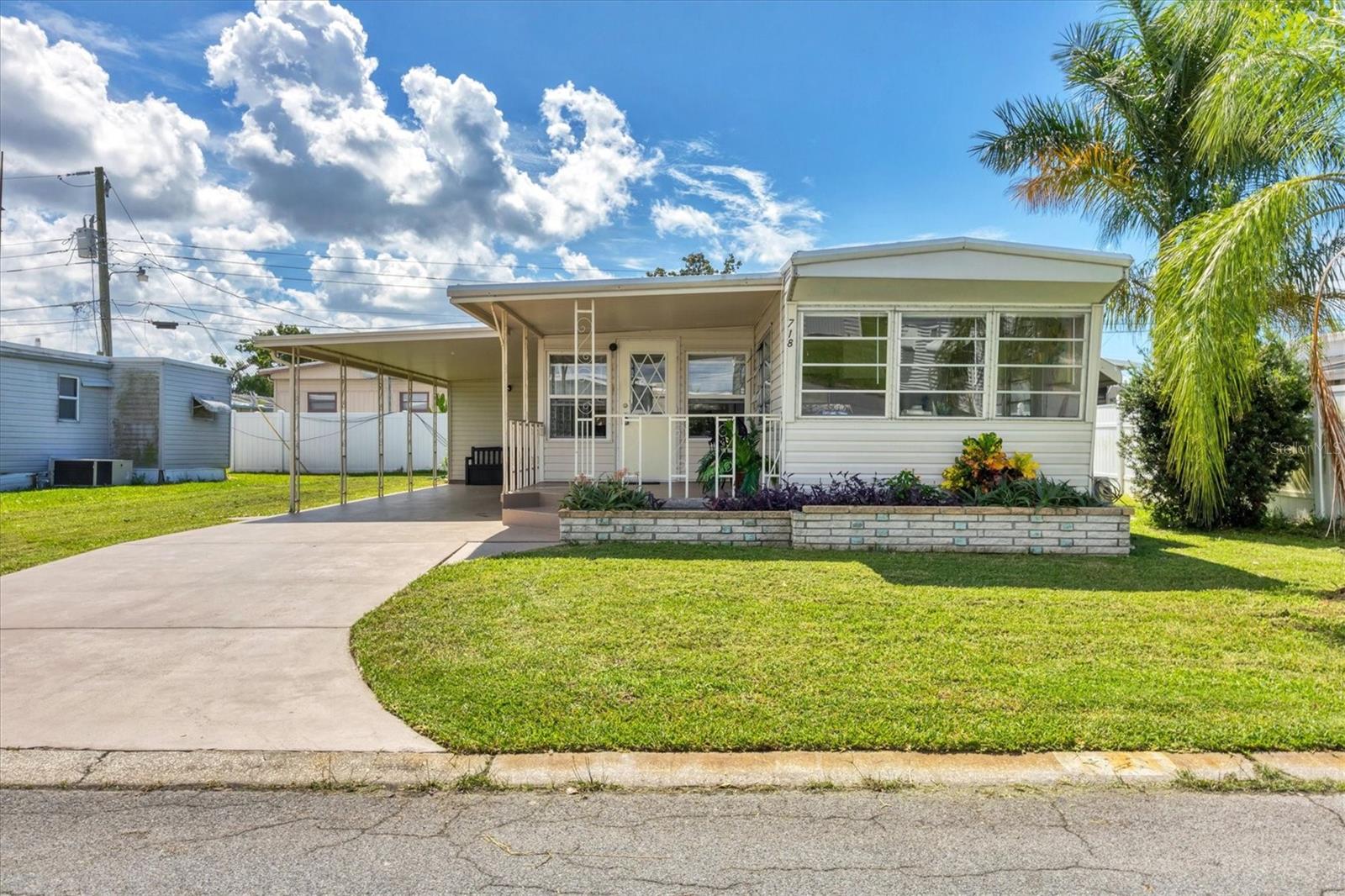 Seller says get this home sold! Come check out this terrific opportunity in the 55+ community of Fair Lane Acres. This community is a LAND OWNED neighborhood with LOW HOA fees. Situated on an oversize lot, this move-in ready home is ready for you whether you are a full time resident or looking for a convenient second home to escape the cold north. This one bedroom and two full bath home has been updated and refreshed with new carpet and vinyl plank flooring through out. The home also boasts a bonus room that can be utilized as a guest bedroom, den or office space. The Florida room is completely modified with glass windows that let in ample natural light and has heating and A/C run to provide full interior usage. The A/C unit was recently replaced in 2023. The kitchen is equipped with stainless steel appliances and has additional cupboards and cabinets for storing all your kitchen needs. The primary bedroom has had new carpet installed and comes with a sliding door closet space and additional shelving and drawers built into the far wall. The recently remodeled primary bath has a shower/tub combo and a single vanity. The second full bathroom is located in the utility area and is complete with separate running water supply and a tiled walk-in shower. The Utility area also provides laundry hook-ups with washer/dryer included as well as storage space. The back patio is covered and perfect for relaxing during a beautiful Florida evening. The HOA provides water and sewer services and gives you access to a clubhouse facility complete with a sparkling community pool and covered shuffle board courts. The community boasts easy access to public transportation and is nearby shopping centers, restaurants, and medical facilities. Schedule your private showing today.