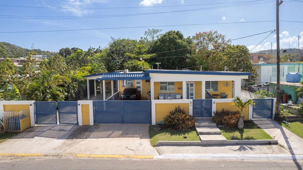 This centrally located and beautifully remodeled home is comfortable, spacious and is conveniently located at just six minutes from town and ten minutes from Esperanza. Located within a one minute walk to a local grocery store, and within two minutes of hardware shops, and restaurants, the property provides easy access to daily essentials while still offering privacy.
The main structure is in excellent condition and has been recently updated. A spacious front balcony provides a great spot to relax, enjoy a morning coffee or lounge on a hammock. Inside, the spacious and open living room has lot’s of natural light while still feeling cozy. To the left, the dining area seamlessly connects to a bar with additional seating - excellent for entertaining, and a modern open-concept kitchen.
This home features a beautifully decorated, full guest bathroom and a versatile guest bedroom with ample space for an office. Two double sized primary bedrooms ample enough for a reading space or a play area each come with built-in closets and private en-suite bathrooms.
Towards the back of the home, before accessing the expansive backyard, you'll find a large laundry/storage room with plenty of space for organization. The backyard is a wonderful tropical retreat—featuring a jacuzzi, outdoor kitchen, multiple lounging areas for entertaining, all surrounded by lush palm trees and foliage providing natural shade and privacy.
To house also has two covered carports with parking for three vehicles. Behind the carport is a separate studio apartment with an unfinished bathroom—perfect for hosting guests or as a future rental unit with income potential. The entire property is fully fenced in for complete privacy and is air-conditioned, providing comfort throughout the entire home.
This wonderful island property with modern upgrades can be an excellent choice for full-time living, vacationing, or an investment.