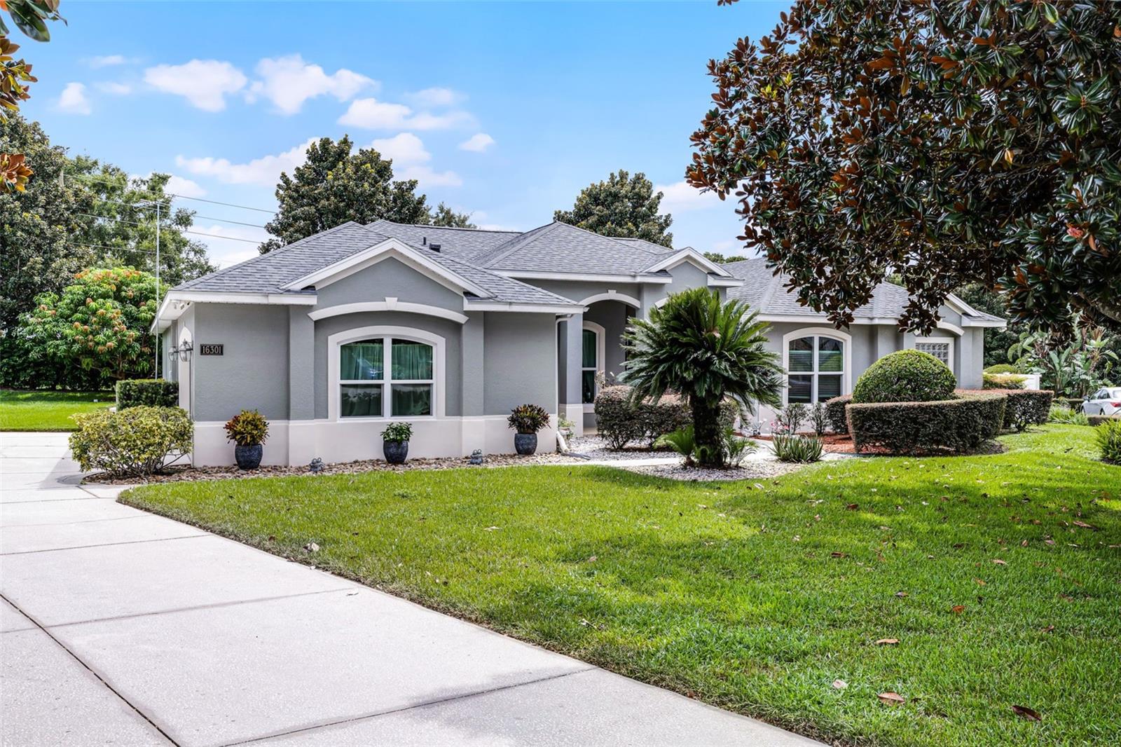 Beautifully maintained 2,800 sq. ft. home on a half-acre lot in Montverde’s sought-after Magnolia Terrace. This 4-bedroom, 3-bath property offers privacy, space, and high-end finishes. Inside, enjoy an open floor plan with granite kitchen countertops, 42” solid wood cabinets, and a flexible layout that includes a private guest suite—ideal for multigenerational living. The living area, and the family room both open to a large screened lanai with a solar-heated, saltwater pool, perfect for entertaining or relaxing year-round. Primary suite features 2 walk-in closets, sliding glass doors with pool views, ensuite bath with garden tub, dual vanities, and walk-in shower. Additional highlights include: *New roof (2020) *HVAC system (2023)* Windows and doors (2022)* Hot water heater (2021)* Freshly painted exterior* Oversized 2-car garage *Laundry room with washer/dryer, storage cabinets, and utility sink. Enjoy fruit trees in the backyard, evening sunsets, and views of Disney fireworks from your patio. Located minutes from top-rated schools, Bella Collina Golf, shopping, dining, and major highways—offering easy access to Central Florida attractions with the peace and beauty of Montverde.