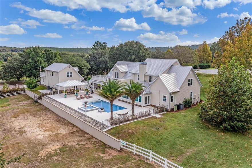 Style and sophistication meet modern farmhouse with this stunning 40-ac equestrian estate located at the foothills of Sugarloaf Mountain and conveniently located in Clermont FL. Renovated and thoughtfully designed, this marvelous property offers impressive spaces that beckon you to relax and enjoy life to its fullest. Whether you're an experienced equestrian desiring a well-appointed facility or simply yearning to homestead on beautiful acreage surrounded by sloping elevations, this one-of-a-kind property in Central Florida has everything you need. With 6 total bedrooms, 4 full & 3 half baths, and 8 garage spaces, the Main home & detached full Apartment incorporate an ideal floorplan that can feel cozy for a few, yet enough space to entertain many. The Main home features a downstairs Master Suite with gas Fireplace, eat-in Kitchen, Office/Den, Formal Dining, Family Room with wood burning Fireplace, and a Florida Room overlooking the property. Upstairs is a Movie Theater with a 110” screen & full immersion experience seating; a Bar; an observation deck with panoramic views of the Sugarloaf Valley; a bedroom off the Theater; 2 Ensuite Bedrooms; and a 5th bedroom currently serving as a Craft Room.  The detached Apartment enjoys its own private observation deck, a full Kitchen, Living Room, Bedroom, and Bathroom. Outside is an expansive Terrace overlooking the property that incorporates a 40x20 beach entry Pool; a massive covered Veranda with gas Summer Kitchen; retractable bug screens; and a separate covered Outdoor Dining space. There's also a large custom firepit with 5 swinging benches to seat 10. Additional features of the home include ample storage; 3yr old metal roof; high-efficiency ACs, doors & windows; water purification system; custom exterior holiday light package; alarm & camera system; and gated entry. The entire property is fenced & cross-fenced into 8 pastures and an arena with over 2.3 linear miles of no-climb & horse-friendly top rail and all 6x6 posts. The two horse barns and 4 run-in barns account for a total of 15 stalls. The 4-stall barn features cameras, AC tack & feed room, racks, counters, rodent-proof feed & hay room, no-fly spray system, and 2-car garage. The newly built 7-stall barn features state-of-the-art rubberized Polyurea flooring surface, Fans in the center aisle and each stall, AC feed & tack room, commercial stainless sink, bathroom, rodent-proof feed & hay room, and no-fly spray system. The property also features a raised-bed vegetable garden with potting shed; a predator-proof chicken coop & run; a 6.5-acre wooded campsite with full RV hookups, dump station, firepit, and a 1500sqf pavilion; an outdoor shooting range with covered shooting house; 2 large ponds stocked with tilapia & speckled perch; and a 1.2-acre grove of organic fruit trees & blueberries.  The property is fully irrigated and there are water stations at all barns and pastures. This amazing property truly has it all, including an ideal location. The Sugarloaf area is only minutes to Clermont, Montverde, Winter Garden, and Mount Dora town centers, and all the shopping, schools, restaurants, hardware and feed stores they have to offer. This property is only a few miles to US-27, SR-50, & the Florida Turnpike entrance; a 30-minute drive to Orlando, MCO Airport, and the attractions; and a 1-hr drive up the Turnpike to Ocala. This is a very rare property for this area. Call to schedule your appointment to see it today before it’s gone!