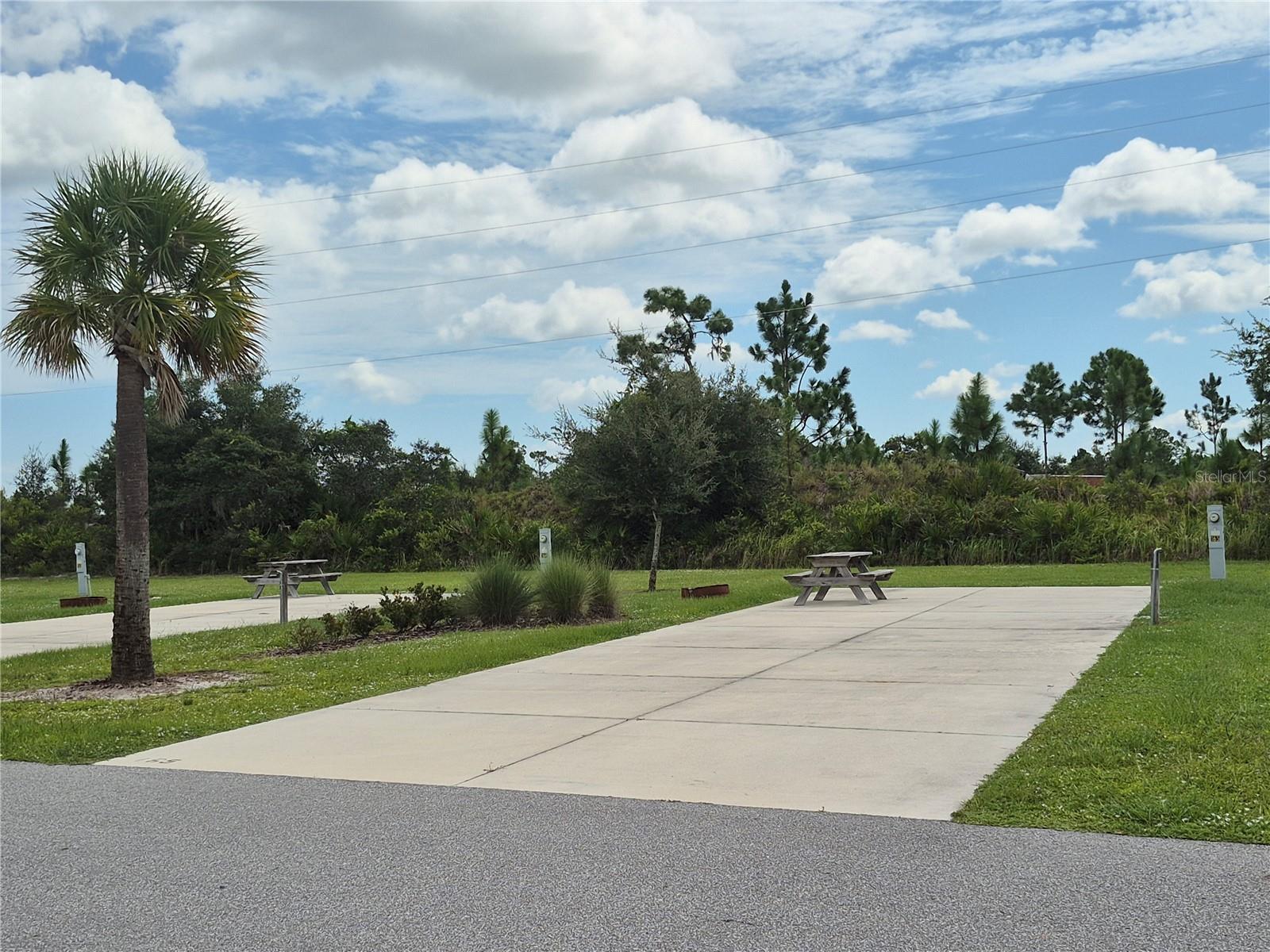 Welcome to the Resort at Canopy Oaks in Lake Wales, Florida! Surrounded by the beauty of natural Florida, this premier RV destination offers resort-style amenities including a large pool and hot tub, a 12,000 sq. ft. clubhouse, full-service tiki bar, on-site café and general store, pickleball courts, shuffleboard, bocce, fishing ponds, dog parks, and picturesque walking trails. This deeded nature preserve site provides a peaceful, private setting with plenty of space to unwind. The generous 20’ x 70’ concrete pad features full hookups (20/30/50 amp) and easily accommodates Class A, Class C, fifth wheels, travel trailers, or even a small park model—making it the perfect carefree seasonal retreat.