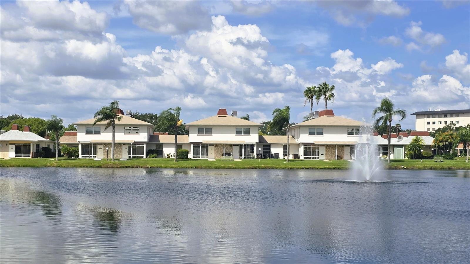 IMMACULATE, WATERFRONT, 2-bedroom, bath and a half townhouse in the GATED 55+ community of Tahitian Gardens can now be yours. This updated townhouse has gorgeous WATER VIEWS and the largest floorplan in the community. Freshly painted with numerous updates! App controlled smart lighting, HVAC and even a smart bath vent with Bose Wi-Fi speakers. The spacious living and dining area feature an abundance of natural light from the oversized living room windows which directly overlook the lake and fountain. Cook and entertain in the updated kitchen with stainless-steel appliances, wood cabinets, custom counters, convenient island and an extra pantry cabinet. Other updates include newer ceiling fans and lighting through-out, custom widow treatments, redone wooden stairs and plank flooring installed in the upstairs area. New irrigation system and sod installed in 2021. The large front windows have hurricane shutters for added safety. The master bedroom features a spacious closet and beautiful lake views from all windows. This is a bath and a half unit with the half bath being conveniently located on the first floor. Includes a full-size front-loading washer/dryer combo unit for your convenience. Enjoy the birds and wildlife right from your patio as you relax and enjoy the lake views and Sunset. The large, heated swimming pool is just a few minutes' walk on the many sidewalks around the lake and throughout the community. Tahitian Gardens is a beautifully maintained 55+ gated community with many activities including shuffleboard, arts and crafts, a bicycling club, bingo, dominoes, card groups and more. Easy access to shopping and public transportation. Tampa and Clearwater airports are less than an hour drive. Walking distance to CVS, Walgreens, and Aldi. Minutes away from Tarpon Springs, the Sponge Docks, and the beach at Howard Park. Furnishings, wall hangings, art, etc. do not convey, but may possibly be purchased separately. Easy to see. Shown by appointment.