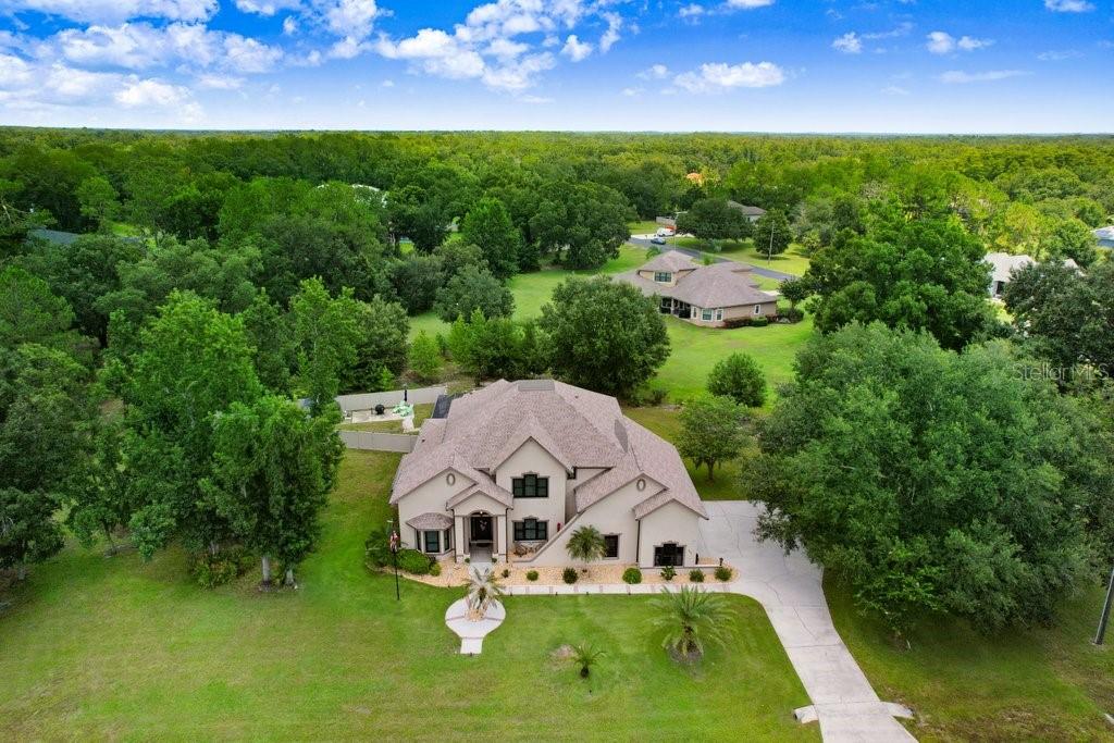 Elegant Two-Story Pool Home on 1.88 Acres in Westwood Estates. Nestled within the gated equestrian community of Westwood Estates, this stunning 3,802 sq. ft. residence offers the perfect blend of luxury, functionality, and serene Florida living. Situated on nearly 2 acres, this 4-bedroom, 3.5-bath home features an office/library, a bonus/media room, and an oversized 3-car side-load garage. Step outside to your private backyard oasis, complete with a self-cleaning saltwater PebbleTec pool featuring a sun shelf and rock waterfall. The screened brick paver patio offers two covered areas ideal for entertaining, while a child safety fence, newly installed perimeter fence with solar lighting, and a storage shed add comfort and convenience. Inside, a dramatic two-story foyer welcomes you with a new modern chandelier, elegant crown molding, and tile accents. The formal living and dining rooms showcase double tray ceilings, while the spacious family room offers peaceful pool views. The gourmet kitchen is equipped with custom maple cabinetry, granite countertops, a stylish tile backsplash, ample pantry space, and upgraded Samsung black stainless steel appliances. A convenient first-floor bedroom with an en-suite bath makes a perfect guest or in-law suite. Additional main-floor highlights include a half bath, mini mudroom, and an oversized laundry room complete with washer/dryer, utility sink, and a second refrigerator. Durable Pergo plank and tile flooring flow seamlessly throughout the main living areas. Upstairs, the luxurious owner’s suite features a tray ceiling, cozy fireplace, generous walk-in closet, and a spa-style bath with dual vanities, a jetted tub, and a dual-head walk-in shower. Two additional bedrooms each feature walk-in closets and share a full bath—one even includes a bonus room perfect for a playroom or home office. The windowless media room is ideal for a private theater setup. Notable updates include a brand-new roof (2025) and all new impact-rated Andersen Cat 3 windows. Don't miss the opportunity to own this extraordinary home—schedule your private showing today!