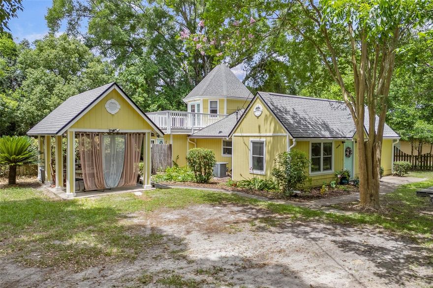 Tucked among serene horse farms, this renovated storybook cottage offers the perfect blend of whimsy, warmth, and modern updates—all just 12 miles from the University of Florida. From the moment you arrive, this home captivates with its architectural charm and unique design. Inside, cathedral ceilings, an updated kitchen and bathrooms, and no carpet throughout create a fresh, open living experience. The primary suite on the main floor is filled with natural light and features a spacious walk-in closet and plenty of room for a desk or sitting area. The primary bathroom includes double vanities, granite counters, and a large walk-in shower with dual shower heads. But the true showstopper? A cylindrical tower room that adds storybook magic and endless versatility—ideal as an office, creative studio, or guest space. French doors from the tower open to a private balcony, perfect for enjoying fantastic sunsets. Outside, the charm continues with mature fruit trees (lemon, grapefruit, kumquat, and pecan) and a detached carport with electricity—ready to serve as a covered parking area or outdoor living space. Whether you’re a professional, artist, retiree, or first-time buyer, this home offers something rare: character you can feel, and convenience you’ll love. Schedule your showing today—this one won’t last!