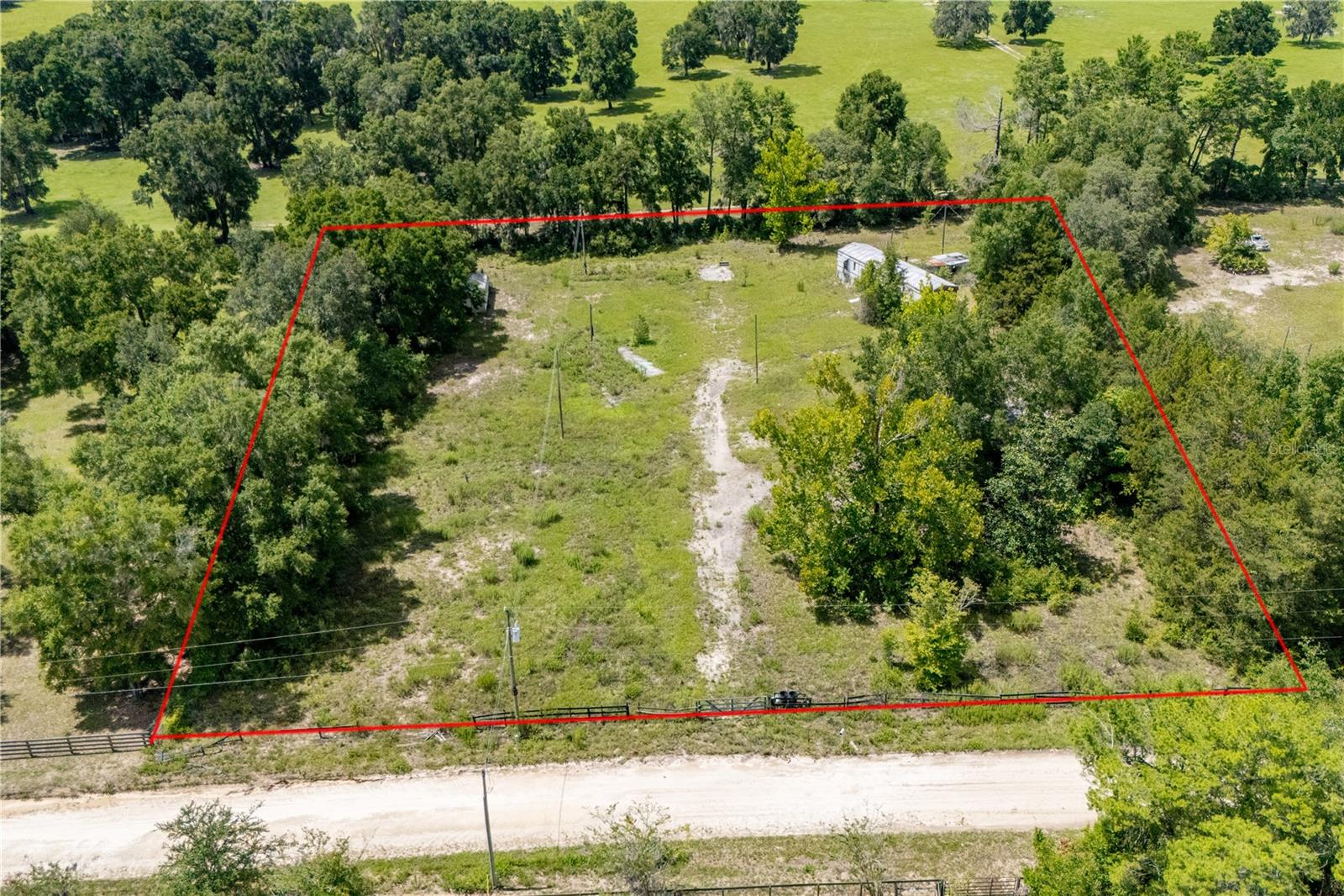 1.84 acres with potential! This property was previously used as a mobile home park and still has two unlivable mobile homes on site. Condition of existing structures is unknown and not considered habitable. The seller states there is an older well and an additional well installed over six years ago—buyers are advised to use the inspection period to determine the condition and functionality of any existing utilities. Conveniently located just off Hwy 27, this property offers easy access and visibility. Great investment opportunity with room to clear and build. enter at your own risk and use extreme caution. Property is being sold as-is, with no repairs or warranties. Utilities on site.