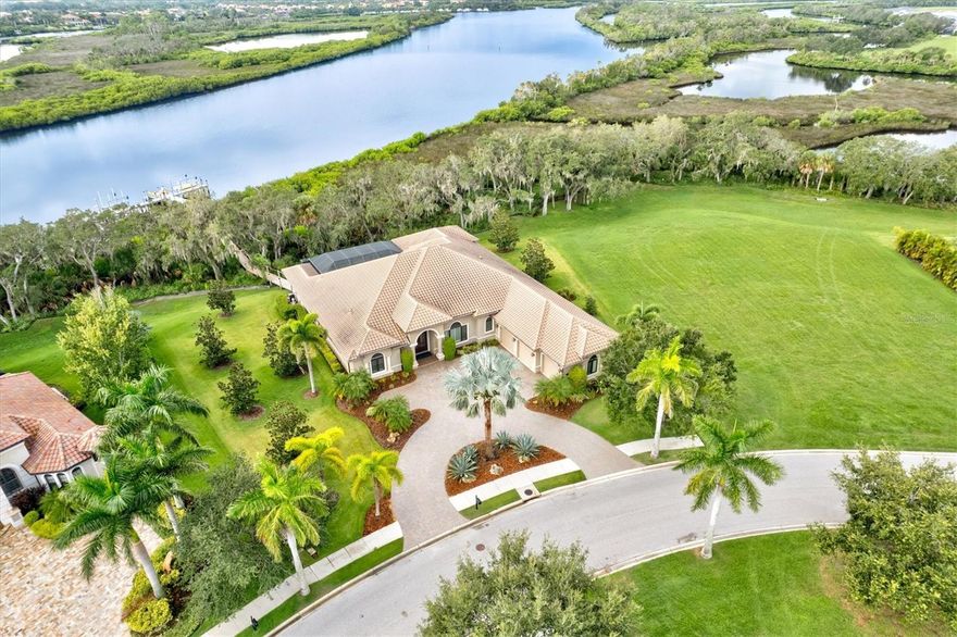 Experience the ultimate riverfront lifestyle in the gated community of The Islands on the Manatee River.  This exquisite custom built 4 bed/4 bath plus den home is located on a premier .59 acre estate size lot, directly on the Manatee River with easy access to the Gulf of Mexico. Relish the tranquil “Old Florida” natural setting with majestic oaks draped in moss framing your backyard view. Step inside to find a roomy open-concept floorplan with tray ceilings, crown molding, plantation shutters, Sonos sound system, central vac and more custom details throughout. The great room features a beautiful custom built-in centerpiece with gas fireplace, creating a cozy ambiance. The gourmet kitchen boasts warm wood cabinetry, granite counters, a large center island and a huge walk-in pantry that’s every chef’s delight. The owner’s retreat is a spa-like haven with dual walk-in custom closets, WC, separate vanities, a walk-in shower and garden tub. Two of the remaining 3 bedrooms are en-suite providing privacy for your family or guests. The spacious lanai is your outdoor oasis, complete with summer kitchen, ample covered space, and a heated pool/spa overlooking the picturesque river. Plenty of storage options with an oversized 3 car garage with plenty of room for a golf cart, the ideal way to traverse the neighborhood. Fully embrace the waterfront boating lifestyle with your impressive 200’ composite dock with 20,000lb & 9,000lb lifts and a platform providing easy access for kayaks/canoes/paddleboards. Relax and observe the rowing teams train, watch for dolphins, manatees and a variety of wildlife along with amazing sunsets from your private dock. The Islands’ amenities include access to the charming River Lodge clubhouse with fitness facility, BBQ area, putting green, bocce, firepit and boat launch. Optional golf, tennis/pickleball, athletic and social memberships are also available at The Club at River Wilderness. Furniture is available under separate contract. A truly stunning waterfront property with so much to offer, it's time to live your best life!