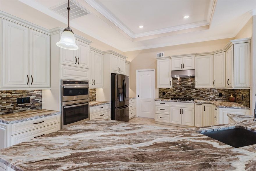 Welcome to this beautifully upgraded pool home located in the highly desirable community of Deep Creek. Offering 3 bedrooms, 2.5 bathrooms, and 2,296 square feet of living space, this property showcases extensive updates and thoughtful design throughout. Step inside to discover new flooring throughout, fresh interior paint, upgraded tray ceilings, and elegant crown molding, creating a bright and refined living space. The fully remodeled chef-inspired kitchen is designed for both functionality and entertaining, featuring gas cooking, wall ovens, and a convenient pot filler. The primary suite has been completely redesigned, creating a true retreat within the home. The luxurious primary bathroom features a zero-entry walk-in shower with a rainfall shower head and body jets, along with a relaxing soaking tub, offering a spa-like experience. Outdoor living is where this home truly shines. Enjoy your private pool with solar heating, a large under-truss lanai, and a peaceful lake view that provides both privacy and a relaxing backdrop. Additional outdoor features include an outdoor shower and a convenient pool bath, making the space perfect for entertaining and enjoying the Southwest Florida lifestyle. The home has also been freshly repainted with added stone veneer accents, enhancing curb appeal and giving the property a distinctive look that stands out in the neighborhood. With its extensive upgrades, private pool, lake view, and desirable location, this home offers a rare opportunity to own a move-in-ready property in one of Punta Gorda’s most sought-after communities.