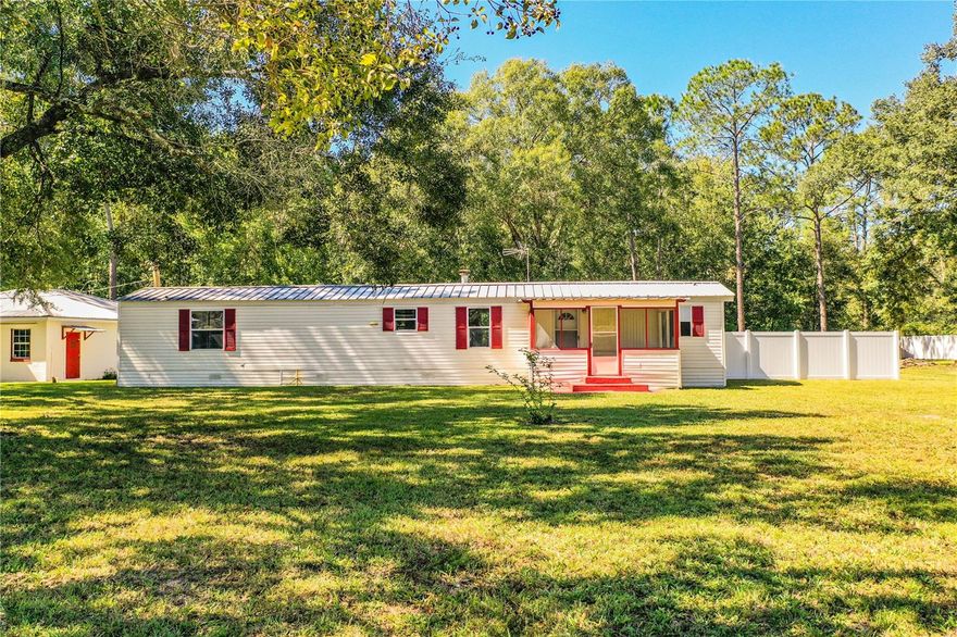 Welcome to this peaceful ranch-style estate nestled on a 3.48-acre lot in a serene countryside setting, far removed from the hustle and bustle of the city.  This location is ideal for those seeking tranquility and ample space, as the property offers an oversized lot adorned with various pine, oak, and palm trees that create a soothing ambiance around the main dwelling.  While the entire lot isn't enclosed by fencing, the portion surrounding the house and additional structures is fully enclosed and secure.  The home itself boasts two bedrooms, each with its own full bathroom, encompassing a total of 1,243 square feet.  As you approach the residence, you'll be greeted by an inviting front screened-in porch.  The house features a durable metal roof, updated double-paned windows throughout, a new HVAC unit installed in April 2022, and a generous 375-square-foot Florida Room.  This room offers breathtaking views of the peaceful backyard, complete with a tray ceiling and a wood-burning fireplace.  Just outside this spacious room, there's a covered back porch for additional outdoor relaxation.  Adjacent to the main house, you'll find a 900-square-foot block building with electricity and water service.  This versatile structure can serve a variety of purposes, such as a garage, storage space, or a workshop.  It even has the potential for conversion into an additional dwelling if desired.  Additionally, three animal pens are available within this building.  The property further includes a two-car covered carport and extra sheds, with one housing the well and a water filtration system.  For added privacy and security, the lot is enclosed by fencing with a locking gate.  This home is move-in ready and exudes a welcoming charm.  Whether you have pets, toys, boats, or work equipment, this property is equipped to accommodate your lifestyle.  Don't miss out on this opportunity, as this exceptional property won't be available for long.  Schedule your appointment today!