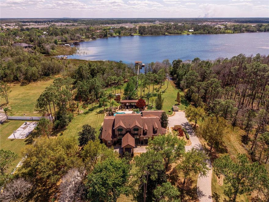 One or more photo(s) has been virtually staged. The Pinnacle of Lakefront Living......Designed to Entertain, Built to Endure, & Positioned to Inspire.  Situated along the shore of spring-fed Bay Lake, this exceptional Estate is the only one with true, North lake frontage and access in Bay Lake Ranch. Being on the cul-de-sac of Ranchero, having private lake frontage, & abutting the 1076-acre Lake Lizzie Preserve, I'd say location & seclusion of this caliber can be very rare.  The home reveals itself as a RETREAT.....indoor elegance that flows seamlessly into expansive outdoor living spaces. Posed for entertaining: a theater room, game room, wet bar, sprawling lanai & summer kitchen, a lagoon-style pool & spa, a fully outfitted PAVILION boasting its OWN SUMMER KITCHEN, & a private boathouse that features 2 lifts, a composite dock/deck, lighting, water, & breathtaking sunsets. Refined interior: PLANTATION SHUTTERS, CROWN MOLDING, EPOXY FLOORS, ELECTRIC FIREPLACE(S), STONE WALL. A Chef's Kitchen without compromise: quartz counters, 2 sinks, wine racks, breakfast bar, walk-in pantry, Bosch induction cooktop, Bosch convection microwave, Subzero refrigerator, 2 Fisher & Paykel drawer dishwashers, Miele steam drawer, 48-bottle wine fridge, Bosch double oven, built-in coffee maker, a potfiller, touchless faucets, 2 disposals, pull-out spice racks, pop-up power station, & much more! Downstairs showcases your Owner's Suite & a 2nd En-suite, both with direct access to the pool lanai. Fit for a King (or Queen), this Owner's Suite has a lit tray ceiling, its own electric fireplace, 2 walk-in closets, & a spa-inspired bath. Stone accents, lavish pass-through shower, multiple rainheads, stunning bay window with bench seating & waterfall glass, dual vanities, built-in storage, & private water closets/bidet. Every additional bedroom offers its own ensuite bath, walk-in showers, & thoughtful design......2 of the upstairs en-suites offer balcony access, & vaulted ceilings. Another level of infrastructure: GENERAC DIESEL GENERATOR equipped to keep the entire property functioning during an outage, updated security & surveillance, cable wired throughout, ADA water closets, new smoke detectors, CENTRAL VACUUM, irrigation system, & a 3-car garage with new epoxy flooring, a half bath, new LED lights, Smart openers, & a keypad. This meticulously maintained LAKEFRONT estate blends luxury, technology, & refinement.....destination-living that is entirely unforgettable. Please inquire on the complete Feature Sheet for this property.
