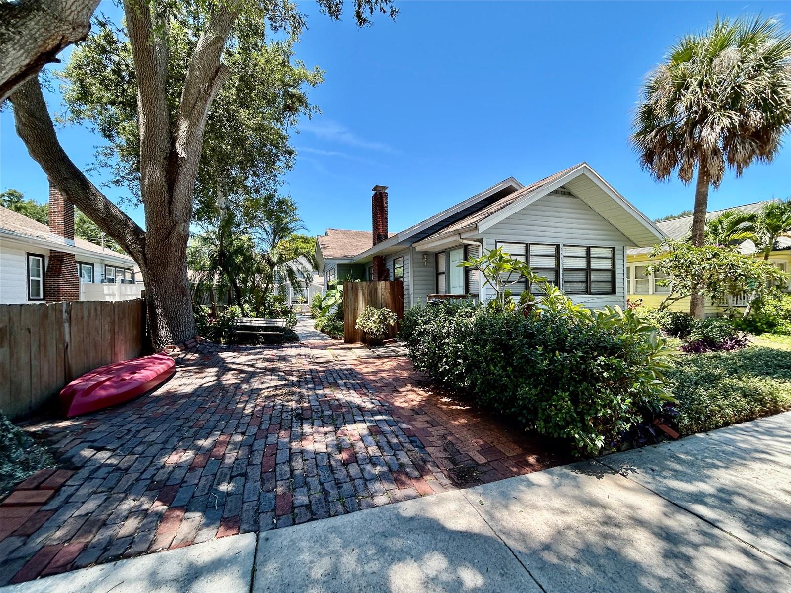 Spacious, charming, and full of character—welcome to this oversized 2-bedroom, 1-bathroom home located in the heart of St. Petersburg. With approximately 1,500 square feet of living space, this unit offers room to spread out and enjoy. Step inside through the tiled foyer into a large living room featuring a working fireplace, followed by a separate dining area with storage space and an expansive kitchen complete with concrete countertops, gas range with convection oven, and a full-size refrigerator—perfect for anyone who loves to cook or entertain. Both bedrooms feature hardwood flooring and the primary is large enough to fit a queen bed with extra space to enjoy. The bathroom includes ample counter space, dual medicine cabinets, and a full tub/shower combo. Outside, enjoy a peaceful garden area and shared patio space, thoughtfully maintained by the owner who resides in the rear unit. Shared laundry is available onsite, and pets are welcome with restrictions. Just minutes from Crescent Lake Park, downtown St. Pete, and major commuter routes, this home blends comfort, convenience, and walkability in one of the city’s most desirable neighborhoods!