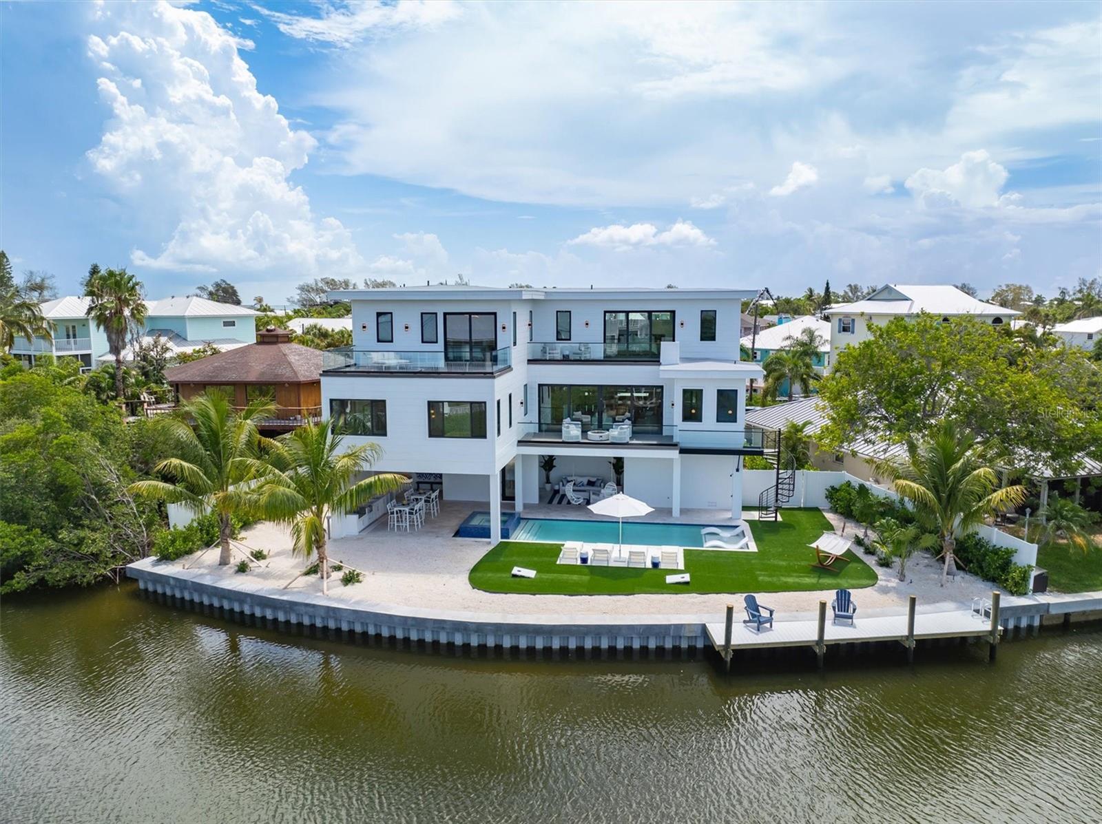 Significant price drop makes this an incredible opportunity!!!! Stunning, brand new construction home with 4 bedrooms, 4.5 bathrooms located on the exclusive North end of Anna Maria Island. This unique, oversized lot sits at the end of a quiet cul de sac and opens onto a wide waterway. The waterfront home is situated to take advantage of sunsets from every room. The open floor plan flows seamlessly to a large deck overlooking the pool and waterway giving you an exceptional indoor/outdoor living feel. The chef’s kitchen is a dream and includes high-end, built-in Thermador appliances, gorgeous custom cabinetry, quartz counter tops and a walk-in pantry. Entertain at your full service bar featuring a beverage and a wine fridge. Completing the main living level is a private office/den. There are 2 oversized master suites with walk in closets, exquisite bathrooms and sliding glass doors opening to expansive decks. The additional 2 large en suite bedrooms also have incredible views. Other features include a large 2 car garage, separate garage to keep your water toys, elevator and more. The backyard oasis may be your favorite as there is a full outdoor covered kitchen and living area with quartz counter tops, grill, stove top, sink, ice maker, beverage fridge, fire table and outdoor shower. Enjoy your sleek, resort style heated pool with Baja entry and covered spa. For the fishermen, there is a large dock to store your boat or fish off the dock. It is just a short stroll to the shops and restaurants of Pine Ave and the world-renowned beaches of Anna Maria. GREAT investment property and currently enrolled in vacation rental program with already over $130k income on the books! Offered turnkey furnished by a professional designer with all of the high-end amenities and furnishings you would expect in this luxury property. Dock your boat and make this piece of Anna Maria Island paradise your own!
