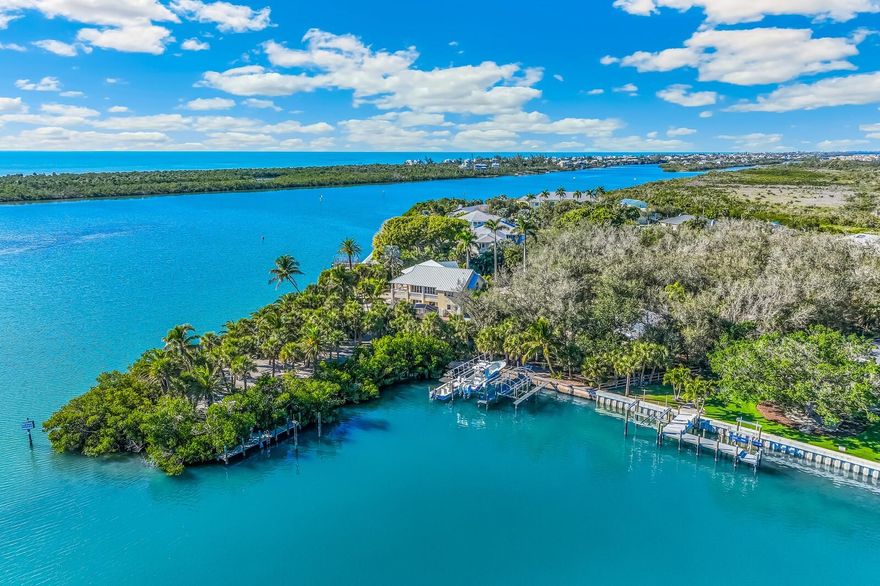 Behind a gated, palm-lined drive, this custom Cape Haze estate unfolds across two expansive parcels totaling 2.62 acres, offering an uncommon sense of scale, privacy, and direct waterfront access on Lemon Bay. Built by J & J Homes for the builder himself, the residence reflects a level of craftsmanship and material integrity rarely found in the market.

The main living level is organized around a light-filled great room, where a wood-lined cathedral ceiling and custom built-ins frame uninterrupted views of the bay. Walls of glass open to a covered veranda, creating a seamless connection between interior spaces and the surrounding landscape.

The kitchen is both refined and functional, appointed with custom wood cabinetry, granite countertops, under-cabinet lighting, a hand-painted sink, copper range hood, KitchenAid appliances, and a Sub-Zero refrigerator. A butler’s pantry and breakfast nook enhance everyday ease, while a formal dining room with crown molding and a sculptural niche is designed for more considered gatherings.

The primary suite is positioned as a private retreat, featuring a double tray ceiling with layered crown molding, an expansive walk-in closet supplemented by two additional closets, and a spa-like bath with an extended granite vanity, gold-plated fixtures, a walk-in shower, and a Jacuzzi soaking tub.

A dedicated office with leaded glass French doors and custom built-in cabinetry offers a quiet, purposeful workspace. A guest suite with water views, balcony access, and an adjacent marble-appointed bath provides comfort and privacy for visitors. A well-placed powder room and a thoughtfully designed laundry room complete the main level.

Outdoors, a heated screened pool and spa overlook Lemon Bay, accompanied by a convenient half bath. The property’s 530 feet of concrete seawall supports exceptional boating infrastructure, including a 16,000-pound lift, a separate 10,000-pound covered lift, Trex dock, fishing station with water and electric, and a dedicated launch for kayaks and paddleboards. Deep-water access to the Intracoastal Waterway is immediate, with Don Pedro Island State Park just across the lagoon.

Additional features include zoned HVAC, tankless water heater, new electrical panel, an attached side-entry three-plus-car garage, and a 1,500+ square foot air-conditioned detached garage and workshop with epoxy flooring.

A composed and enduring waterfront estate, defined by craftsmanship, privacy, and a rare depth of waterfront presence.