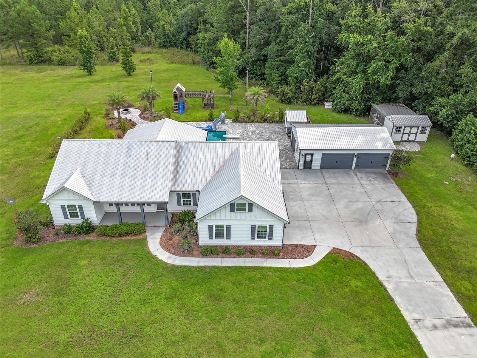 This quintessential country retreat located just north of the city of Callahan, situated on 15.05 acres m/l, is ready for its new owner. Let's jump right into the details! Entrance to the property is gated, and the driveway is paved. The main residence is a single-story home with a split floor plan. The primary bedroom has an en-suite bath and walk-in closets complete with a built-in shelving system. The laundry room has its own sink and a half-bathroom for guests is in this same hall. The kitchen, living room and dining area are open concept, with a volume ceiling and kitchen island. Within this gathering area, French doors provide both a clear view and direct access to, the covered back patio. Opposite the primary bedroom, a full hall bathroom separates bedrooms two and three. A covered front porch and attached, two-car garage complete the main residence. Outside, the amenities continue! Paver blocks extend from the covered patio area and surround the inground pool, which has a slide! And for the cooler months, there's a fire pit for roasting marshmallows. The front of the parcel is grass and the back of the parcel is treed. Additional storage needs are satisfied with a detached 2-car garage and a wooden shed. Property sold "As-is". Buyer and/or buyer's agent responsible for verifying all pertinent information deemed relevant by the prospective buyer, including but not limited to square footage, acreage, utilities, taxes, zoning, permitting, condition, school zones, HOAs, etc.