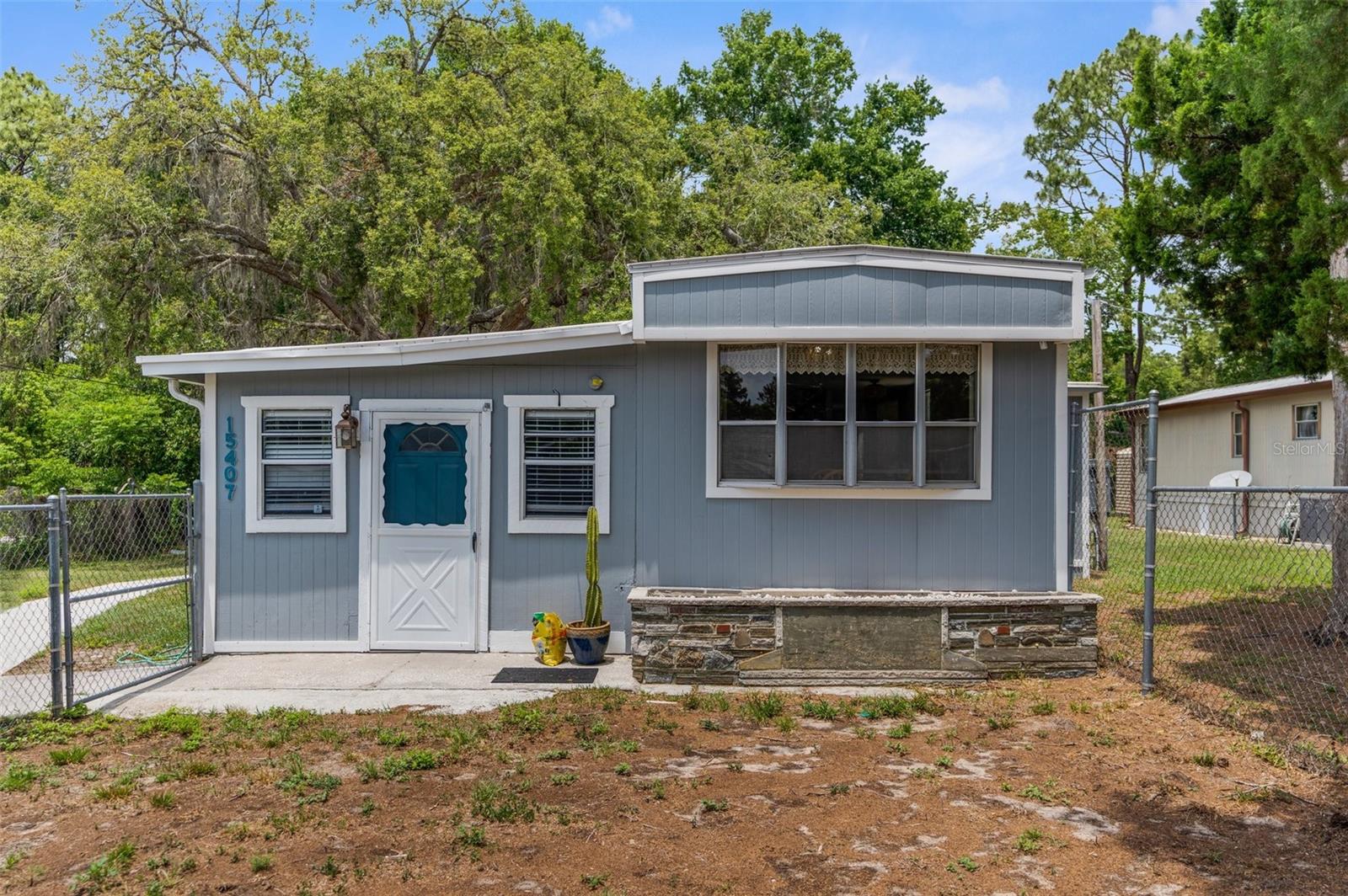 PRICED BELOW RECENT APPRAISAL! BRAND NEW AC & BRAND NEW ELECTRICAL PANEL! Welcome to your new home! This cottage style charming and affordable mobile-home offers a cozy and updated living space in a fantastic location within a wooded setting. What a gem, at an amazing price point! Enjoy the open floor plan, spacious kitchen, and newly remodeled master bedroom- with a beautiful walk out to mature oak trees in a picturesque setting. You'll have peace of mind with a roof that is only 5 years old which is covered by a warranty for an additional 10 (10 year transferable warranty), and transferable termite insurance. There is ample space for outdoor activities and a concrete shed for extra storage! Not to mention it is nestled on a deadend street (!!), which means no through traffic! Two bedroom, with an office area AND an addition which can be used as a flex space make this floor plan very versatile! Do not miss out on this fantastic opportunity- schedule your viewing today! Owner willing to pay 2500 toward closing cost!