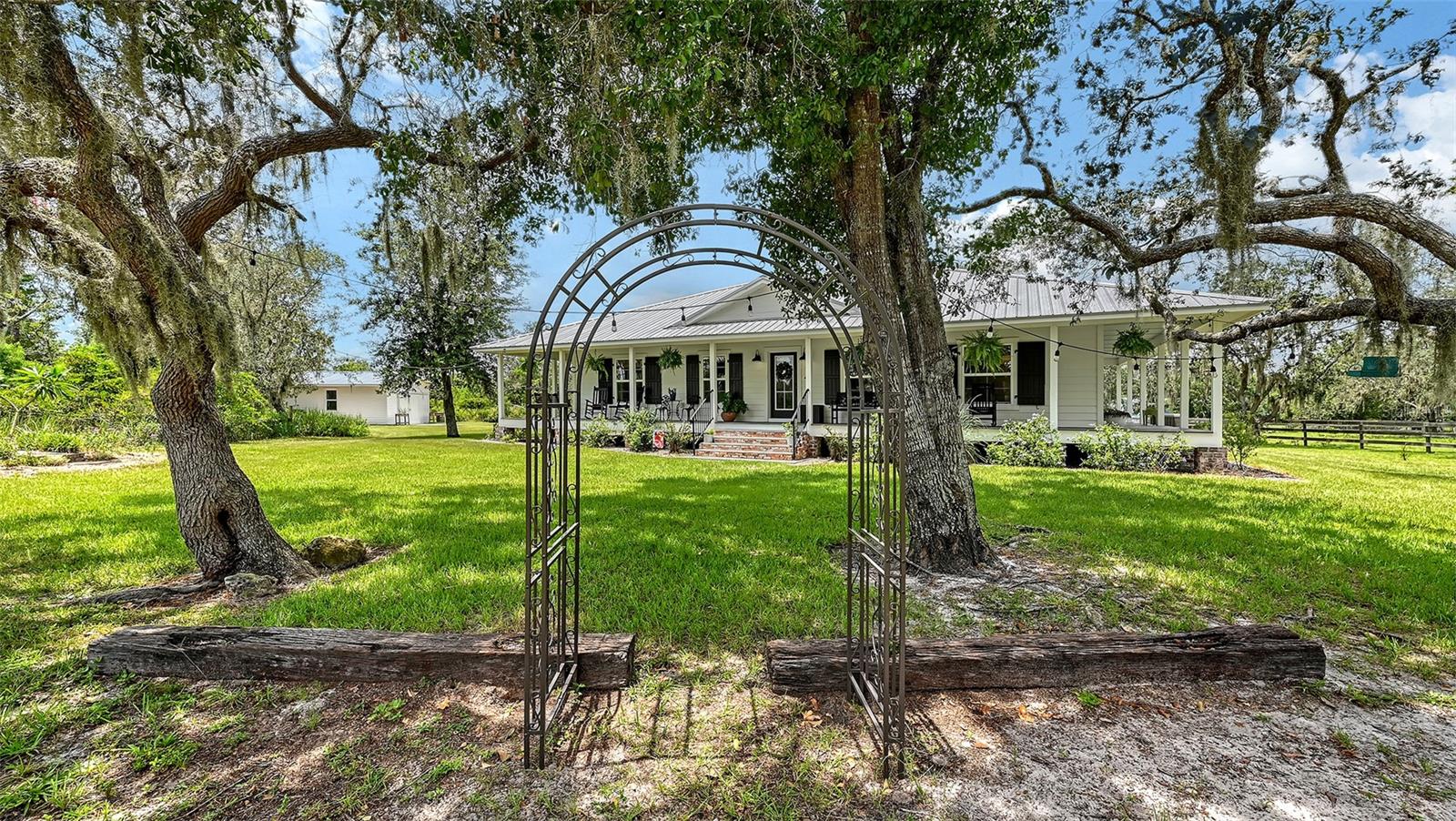 Nestled in the tranquil heart of Myakka City’s countryside, this breathtaking Florida Cracker masterpiece, built in June 2020, is an over-engineered fortress of timeless elegance and unmatched hurricane resilience. Set on 10 pristine, wetland-free acres, this private sanctuary is framed by majestic oak trees and three-board fencing, tucked far from the road for serene seclusion. A shimmering pond stocked with vibrant blue tilapia enhances the idyllic landscape, beckoning equestrian enthusiasts, cattle ranchers, or those yearning for a life woven with nature’s beauty. Crafted to defy Florida’s fiercest storms, this home is a paragon of sturdiness, boasting a durable metal roof, Miami-Dade certified Low-E windows and doors, and Charleston-style hurricane shutters. Over-engineered with 54 robust footers, it stands resolute in Zone X, the premier flood zone, requiring no flood insurance—a rare gift of peace of mind. A propane tank powers a tankless hot water heater and KitchenAid gas range, ensuring uninterrupted comfort even in the worst conditions. A wrap-around porch encircles the front, sides, and back, inviting you to savor sunrises or sunsets under towering oaks. The estate’s fencing and cross-fencing make it ideal for horses or livestock, complemented by an expansive barn with a storm-ready metal roof, offering vast storage, several stalls for equestrian or farming needs, and an attached dog kennel for pet-friendly convenience. A detached one-car garage/workshop adds versatile functionality for projects or storage. Inside, soaring vaulted ceilings create grandeur in the open-concept great room, kitchen, and dining area, floored with state-of-the-art, high-durability bamboo built for heavy traffic yet radiating warm, natural elegance. The gourmet kitchen shines with white shaker-style cupboards, soft-close hinges, quartz countertops, a butcher block island, and the propane-powered KitchenAid gas range for precision cooking. The seamless flow between spaces fosters effortless entertaining, with every detail reflecting the warmth of Florida Cracker architecture, enhanced by modern construction from 2020. The primary suite is a luxurious haven, with a spa-inspired bathroom featuring a large walk-in shower, while the guest bathroom exudes vintage charm with an original 1920s claw-foot tub. Modern comforts abound, from the tankless propane-powered hot water heater ensuring endless hot water to the energy-efficient design of the Miami-Dade Low-E windows and shutters. The property is a lifestyle triumph, perfect for tending livestock in the fenced pastures, fishing in the stocked pond, or crafting in the barn’s spacious workshop and stalls. Whether dreaming of a gentleman’s farm, an equestrian paradise, or a private retreat, this estate delivers with unyielding strength and grace. In Zone X, with no wetlands and 10 acres of usable land, this over-engineered sanctuary is a legacy of Florida’s heritage, blending hurricane-ready fortitude with countryside charm. A true haven where luxury meets invincibility. LOCATION LOCATION LOCATION! Rodeo, horses, equestrian trails! It's all close by! Just 6.7 miles from TerraNova Equestrian Center, enjoy world-class Dressage, Hunter/Jumper shows, and World Class Eventing. Arcadia’s All-Florida Rodeo (20 miles away) thrills with bull riding and barrel racing, and Myakka River State Park (7 mi) offers 12 mi of horse trails. The location gives you a true equestrian paradise!