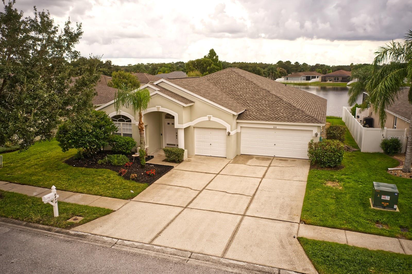 You will truly feel like you’ve just "struck gold" the minute you enter 5316 Strike The Gold Lane with its soaring ceilings and beautifully detailed crown molding that give a sense of grandeur the moment you walk through the double front doors. This move-in ready one-story home in the desirable Lexington Oaks Golf Community in Wesley Chapel features a spacious four-bedroom split-plan. Fresh interior paint, brand-new flooring, and stainless steel appliances leave nothing for you to do but start packing! The primary suite offers sliding doors to a covered patio with serene water views and an en suite bath with a garden tub and separate shower enclosure. A brand-new roof (March 2025) is just what the doctor ordered for your homeowner’s insurance needs. Brand new garage door openers will give you access to your 3 spacious garage bays. Lexington Oaks residents enjoy outstanding amenities including a heated pool, fitness center, tennis and basketball courts, playgrounds, trails, and more. Golf enthusiasts can enjoy the private Lexington Oaks Golf Club. Play 18 holes and then have a post round bite at Omari’s Bar & Grill on site. Conveniently located near I-75, you’ll be just over an hour away from Florida’s beautiful Gulf Coast beaches and 90 minutes away from Orlando’s theme parks. Just 3 miles down the road from The Grove at Wesley Chapel and a short 15 minute drive to The Shops at Wiregrass, there is no shortage of shopping and dining options right in your backyard. This is a golden opportunity you don’t want to miss! Schedule your private showing today!