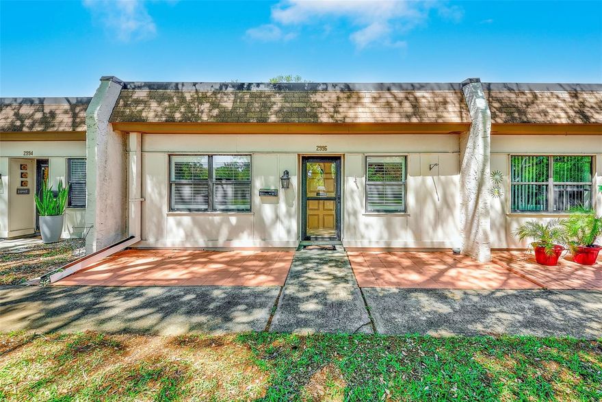 Welcome home to this beautifully updated 2-bedroom, 2-bathroom villa with a covered carport and additional storage, located in the desirable 55+ community of Mission Hills. The renovated open kitchen features granite countertops, a gas range, double sink, ample wood cabinetry and generous counter space, making it both stylish and functional. Inside, you’ll find a spacious living and dining area, a dedicated laundry closet with washer and dryer, a 2022 HVAC system, plantation shutters, and bamboo and tile flooring throughout.
The primary suite offers generous closet space and a beautifully updated bathroom with a walk-in shower. A comfortable second bedroom and neutral guest bathroom provide the perfect setup for visitors. Just off the living area, a versatile bonus room opens to a rear courtyard, while both front and back patios offer inviting spaces to relax or entertain. The monthly fee includes cable, internet, natural gas, water, sewer, trash, roof, exterior and grounds maintenance, use of community amenities, and land lease. Mission Hills is an active, well-maintained community with a clubhouse featuring a social room, library, fitness area, billiards, ping pong, shuffleboard, and a large heated community pool. Conveniently located in Clearwater, this home is just minutes from shopping, dining, grocery stores, hospitals, airports, entertainment, the charming downtown areas of Safety Harbor and Dunedin, and the beautiful Gulf beaches.