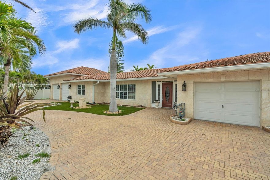 Discover this exceptional rare double lot (approximately 110 ft wide) in the highly sought-after Carlouel neighborhood on Clearwater Beach. 
The existing residence sustained damage from Hurricane Helene and is now a blank slate ready for full renovation or complete rebuild. Behind the home awaits an outstanding outdoor oasis featuring a spacious paver patio, refreshing pool and spa, and mature, lush tropical landscaping that provides privacy and tranquility. One of the standout features is the expansive garages—one of the largest on the island—capable of accommodating 12+ vehicles w/lifts, making it ideal for car enthusiasts, boat storage, or additional parking needs. This property offers an incredible canvas for your dream coastal home. Just a short walk to private beach access, serene sunsets, and the nearby Carlouel Yacht Club, with the vibrant amenities of Clearwater Beach only minutes away. This is a unique chance to create your perfect island retreat in a prime location.