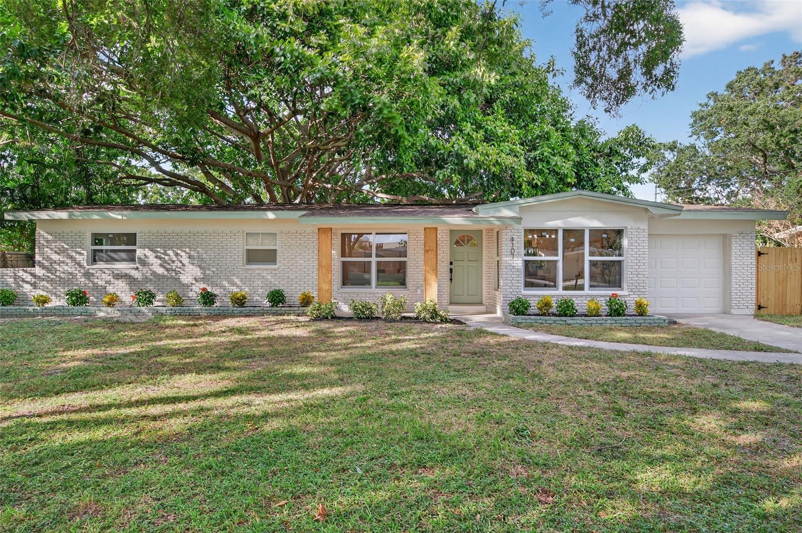 Welcome to your beautifully renovated South Tampa home! This stunning 3 bedroom, 2 bath home with a 1-Car Garage offers 1,488 square feet of thoughtfully designed living space. Major updates include 2025 Roof, 2025 HVAC system, 2025 hurricane-impact windows, updated electrical, and fully renovated kitchen and bathrooms. Every surface has been refreshed, from new luxury vinyl plank flooring and baseboards to interior doors, lighting, and hardware. The curb appeal impresses with wood pillars, green accents, a long driveway, and fresh landscaping. As you step inside, you’re immediately greeted by a bright, open-concept layout that seamlessly connects the living and dining areas, filled with natural light and neutral finishes. The living room features a built-in fireplace, creating a warm and inviting atmosphere. The home offers multiple dining options with a formal dining area, casual coffee table seating, and countertop seating in the kitchen, providing plenty of space for meals and gatherings. The designer kitchen features an L-shaped countertop with plenty of countertop space, quartz countertops, tile backsplash, stainless steel appliances, ample cabinetry, and a wet bar with wine cooler, perfect for hosting and everyday cooking. Step outside the sliding glass doors into the spacious, fully fenced backyard, featuring a brand-new tiled patio and a magnificent banyan tree. The primary suite is a serene escape with an ensuite bath featuring designer tile work, a frameless glass shower, and contemporary fixtures. Both guest bedrooms are oversized, offering flexibility for a home office or gym, and share a beautifully renovated full bath with a large vanity and modern finishes. The one-car garage is oversized, providing plenty of room for parking, storage, or a workspace. Located in the heart of South Tampa, this home offers the perfect balance of quiet residential living and unbeatable convenience. You’re just minutes from Bayshore Boulevard, the Selmon Expressway, Downtown Tampa, MacDill AFB, Hyde Park, and Downtown St. Pete, plus top-rated restaurants, shopping, and everyday essentials. This home is truly move-in ready and perfectly positioned in one of Tampa’s most desirable neighborhoods. Schedule your private showing today!
