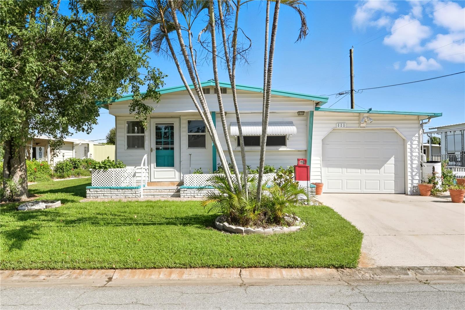This lovely two bedroom one-and-a-half-bathroom home offers the ideal living space for a easy lifestyle. The mobile home lives like a bright open cottage with its sunny front room, flanked with windows and pretty Mexican Tile flooring. This is the perfect spot for you morning coffee or afternoon beverage, perfect sitting room, or den, or office space! The front room leads to the open kitchen living and dining room, all which allows a seamless flow, perfect for entertaining! The oversized laundry/workshop is attached to the garage and can serve as a man cave/studio or storage and has its own ac unit. Inside this home is a new multi zone ac system, still under warranty, it keeps the home cool and control air quality! A 220 Amp electrical panel has been replaced, new vapor barrier underneath and a new hot water heater! The kitchen has plenty of countertops and cabinets PLUS all new appliances, including an induction range and a water filtration system. You won't find any carpet in this home which makes cleaning quick and easy. The primary bedroom has a brand-new adjustable bed! There is a queen sofa bed in the living room and a beautiful oak dining set. Truly move-in ready! The updated windows add to your energy efficiency. The large garage has a new electric overhead opener and will protect your car from the Florida sun. Two additional sheds outside offer plenty of storage. Pretty garden area and pavers on the side offer a place to sit and chat with neighbors. This friendly community is beautifully maintained, has a very low quarterly HOA fee and is conveniently located. Public transportation is nearby as is SRQ airport, the gulf beaches and shopping and dining. There is a public golf course at the end of the community. Your furry friends are welcome! Perfect for a winter retreat or retirement living; this incredible value won't last long! Schedule your showing today!