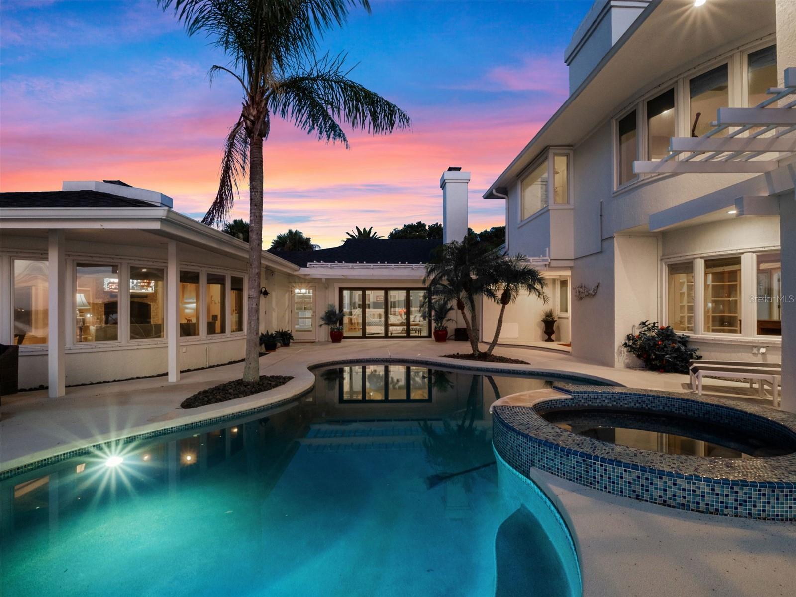 Welcome to 1215 Commodore Dr, New Smyrna Beach, FL—a truly spectacular waterfront view estate where luxury and coastal living blend seamlessly! This stunning 4-bedroom, 3.5-bath home boasts an expansive 4,395 sq ft of meticulously renovated living space, with over $1 million in renovations, that set a new standard for elegance. Discover a chef’s dream kitchen featuring a 8-burner Viking range, double oven, and Subzero refrigerator—perfect for entertaining. The home’s four fireplaces create a warm, inviting ambiance throughout, while two primary suites located on the first and second floor for the ultimate comfort and privacy for family or guests. Enjoy breathtaking direct Intracoastal Waterway views from nearly every room. The outdoor oasis is a boater’s paradise, complete with a 20,000 lb. boat lift, two jet ski lifts, and a full-house generator for peace of mind. Relax in the heated saltwater pool and spa, surrounded by lush landscaping and serene water vistas. Nearby, you’ll find local favorites like Norwood’s Eatery & Treehouse Bar, The Garlic, including the vibrant Canal St district, with its charming shops and restaurants, is just minutes away. This is a rare opportunity to own a move-in ready masterpiece in one of New Smyrna Beach’s most coveted and gated neighborhoods, Yacht Club Island. Experience the ultimate in waterfront luxury—schedule your private tour today!