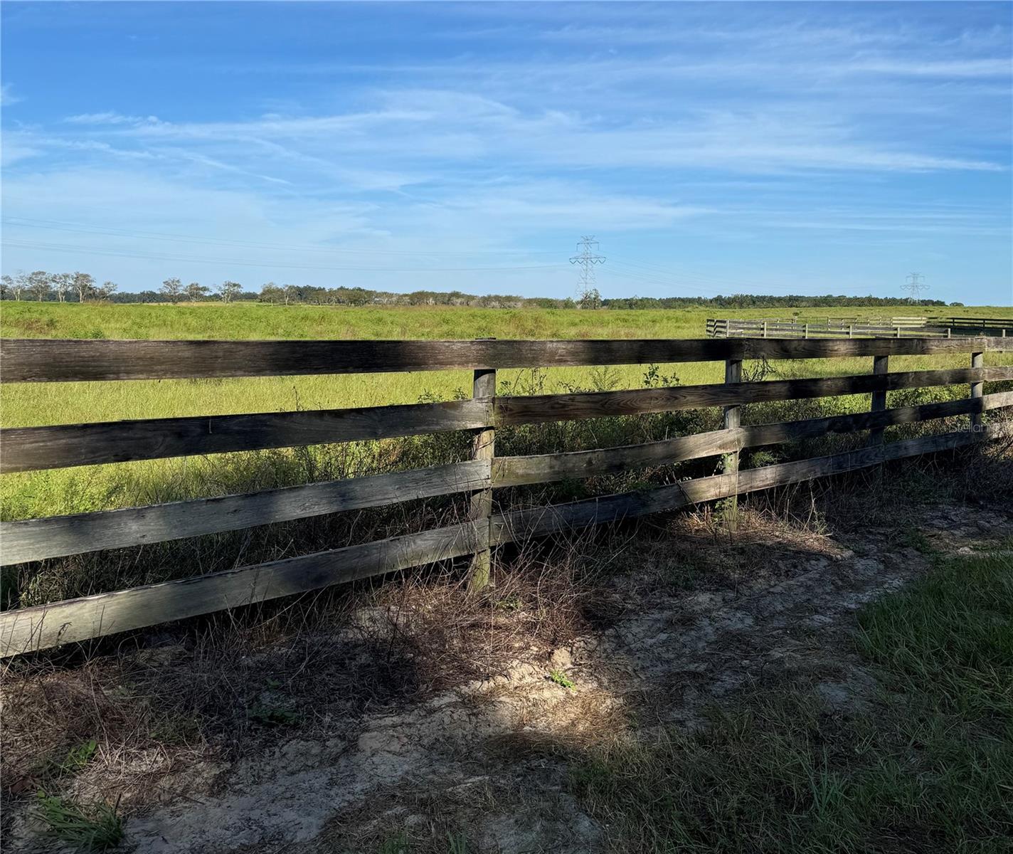 New “HARMONY ESTATES” has convenient access to The Villages with 2-minute drive for shopping, restaurants, medical and entertainment.
This 12.45 acre property is just one of six 11-13+ Acre Country Parcels which could be combined. NO HOA, fees and NO wetlands. Cleared, improved pastureland with paved road frontage and protective covenants. Zoned A-1 for gardens and farm animals. If you are looking for a peaceful, yet convenient place to build a dream home, this is for you! Owner financing available.