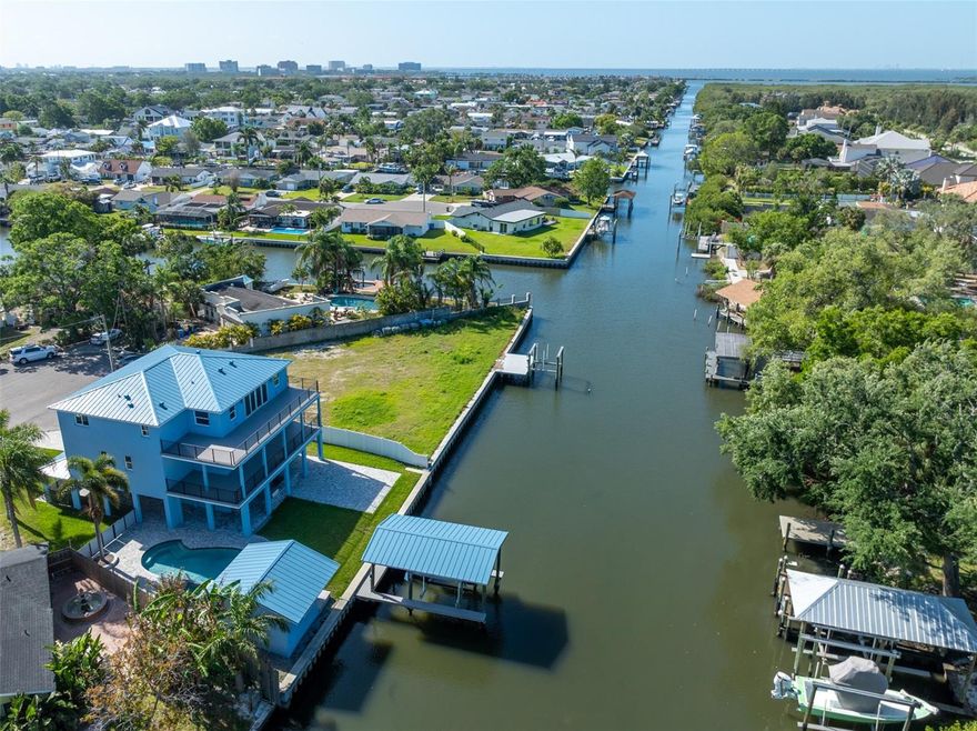 Luxurious elevated waterfront living just became your reality. This NEWLY CONSTRUCTED CUSTOM waterfront stunner with resort inspired pool oasis, plus a detached pool house, and private covered dock with lift located on a peaceful short canal that leads 5 minutes out to Tampa Bay is loaded with spectacular touches and additions that are sure to make your jaw drop…and if that isn't enough, the seller is offering owner financing! With 3 floors of all block foam filled celled construction each story with a sparkling panoramic view of the water, and impact windows. This home isn't just beautiful, it's a fortress. Throughout this custom smart home you will find unique custom designs that make every room feel elevated and personalized smart home technology ran by Control4 that makes this home automated from the touch of a pad or your phone. Every inch of this home was thought out with intention. From the spectacular views with two ENOMROUS balconies (second floor covered with ceiling fans and the third floor open for sunning) and a wide open pool deck with expansive outdoor kitchen and yard perfect for entertaining, to the magnificent open living area with chic kitchen and dining area loaded with high-end appliances and beautiful quartz waterfall countertops, to the 12 foot wide accordion doors that open out to your oversized covered balcony making indoor outdoor living a reality, the 3-stop oversized elevator, hardwired speakers and wifi extenders, premium standing seam metal roof, impact windows, extra tall 8 foot high by 16 foot wide garage door with 9 foot ceilings and over 38 foot deep garage, composite decking, Control4 home automation system, 2 primary bedrooms, the list goes on and on. 
The exquisitely designed primary suite has its own balcony access along with not one, but two large walk-in closets, and the bathroom is like something out of a spa dream. The double entry enormous uniquely designed tile shower plus separate bath tub and heated toilet just might leave you speechless! 
The third floor has 3 more bedrooms, one of which is a second primary suite! 
Endless space for entertaining with an open living/dining/kichen on the second floor and separate HUGE media room and open game room with wet bar on the third floor that leads out to the open third floor balcony for serious sunset action. Even the massive 4 car tandem garage was well thought out. It has an 8-foot-tall garage door to get your large trucks or boats in and measuring over 38 feet deep. The garage also has another large space off to the right that could be large workshop or easily walled off for many other uses.
Let's talk location: This tranquil waterfront community is 8 minutes from Tampa international airport and International Mall, a quick 5 minute boat ride out to Tampa Bay, and 15 minutes from all the action of downtown Tampa and Raymond James Stadium.
Some people have to choose between living on the water with a pool and having a big yard, but here….you have it ALL! With THIS new elevated home…you get both a spacious home, huge pool/spa area complete with a massive outdoor kitchen, private covered dock, pool house for your “man cave” or “she shed”, AND a large yard along the waterfront…all that leads out to the bay.
Properties like this don't come around often. This is your chance to live the Florida dream in a home that dreams are made of.