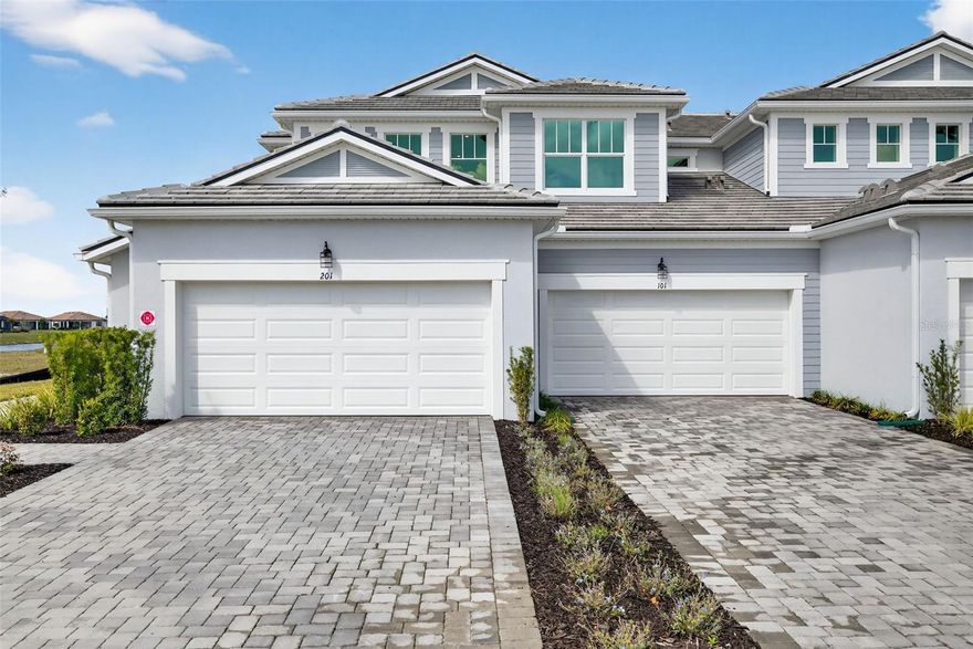 This beautifully designed first-floor coach home delivers 1,406 sq. ft. of light-filled living space with 2 bedrooms, 2 full bathrooms, and a powder bathroom, blending comfort, style, and easy-living convenience. An open-concept layout creates a smooth, natural flow from the dining area to the kitchen and great room, making everyday living and entertaining feel effortless. The kitchen shines with soapstone-inspired quartz countertops, abundant white shaker cabinetry, stainless steel appliances, and an inviting island breakfast bar that seats five. A unique linear-pattern tile backsplash adds a modern touch, while the walk-in pantry enhances storage. The spacious primary suite offers a peaceful retreat with a large walk-in closet featuring shelving on three walls and an elegant primary bathroom with a raised dual-sink vanity, oversized shower with a ledge, linen closet, and private water closet. The split-bedroom layout ensures privacy, with the second bedroom and full bathroom thoughtfully positioned on the opposite side of the home. Sliding glass doors open to a screened lanai—perfect for relaxing mornings or breezy evenings. Additional features include 8-foot interior doors, a conveniently located laundry room near the garage that keeps noise away from the living spaces, and a ClareOne Smart Home Technology package for everyday convenience. Residents also enjoy access to community amenities, including a resort-style pool, shaded cabana lounges, a dog park, play spaces, an event lawn for outdoor activities, and scenic walking paths—plus close proximity to Downtown Wellen’s waterfront dining, lively entertainment, weekly events, and the area’s most beautiful Gulf Coast beaches, placing endless fun and outdoor enjoyment just minutes from home.
***Photos, renderings and plans are for illustrative purposes only and should never be relied upon and may vary from the actual home. Pricing, dimensions and features can change at any time without notice or obligation. The photos may be from a furnished model home and not the home offered for sale.