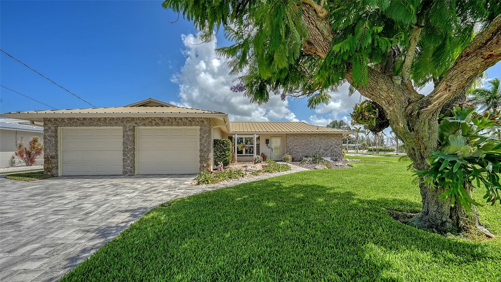 This beautifully maintained 2-bedroom, 2-bath canal-front home in Coral Shores offers the perfect blend of coastal charm, modern convenience, and investment potential—just 3 miles from the white-sand beaches of Anna Maria Island. Boaters will love the private dock with lift, equipped with electric and water, offering direct, bridge-free access to the Intracoastal Waterway and the Gulf. The home features impact windows and doors, a durable metal roof, and an open layout that supports easy, breezy Florida living. Step out to the screened-in porch and enjoy peaceful mornings by the water, spend your afternoons fishing or cruising the coast, and fire up the grill in the evening to entertain family and friends outdoors. The tranquil backyard setting and canal views invite you to unwind and embrace the relaxed Gulf Coast lifestyle. Whether you're looking for a full-time residence, vacation home, or income-producing property, this one delivers. Short-term rentals are allowed, adding flexibility and value. With a prime location near Anna Maria Island, IMG Academy, shopping, dining, and top boating spots, this home checks all the boxes. Schedule your private showing today.