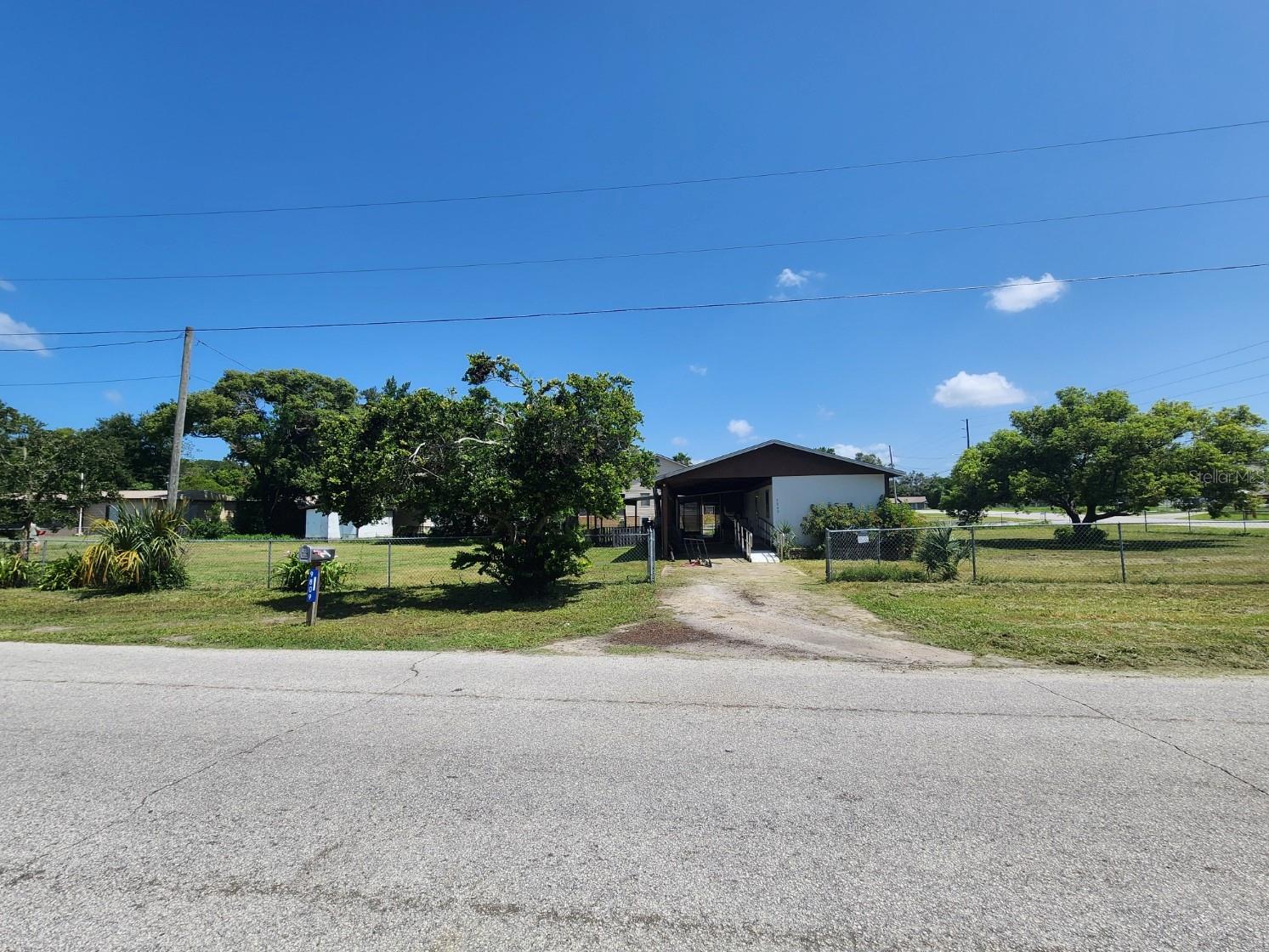 Affordable Mobile on Fenced Corner Lot – Tons of Potential!
Welcome to 9809 Fred Street, a 2-bedroom, 1-bath mobile home situated on a generous, fenced corner lot in Hudson with no HOA. Whether you're an investor or handy buyer, this property offers a great opportunity to build equity with your own improvements.
Inside, you’ll find updated vinyl plank flooring throughout, an open living/dining space with sliding glass doors leading to a screened patio, and a charming kitchen featuring tile countertops, double sink, and a stainless steel range. Both bedrooms include ceiling fans and natural light, and the full bath features a tub/shower combo with washer and dryer hookups conveniently located inside. A hall closet provides bonus storage space.
Outside, enjoy the covered carport with handicap-accessible ramp, an additional shed, screen room, and a chicken coop — all sitting on a flat lot with mature trees and space to expand or customize.
The home needs repairs, including the roof over — and is priced accordingly. Seller is motivated and willing to negotiate a credit toward roofing costs.
Listing Agent is Related to Seller.