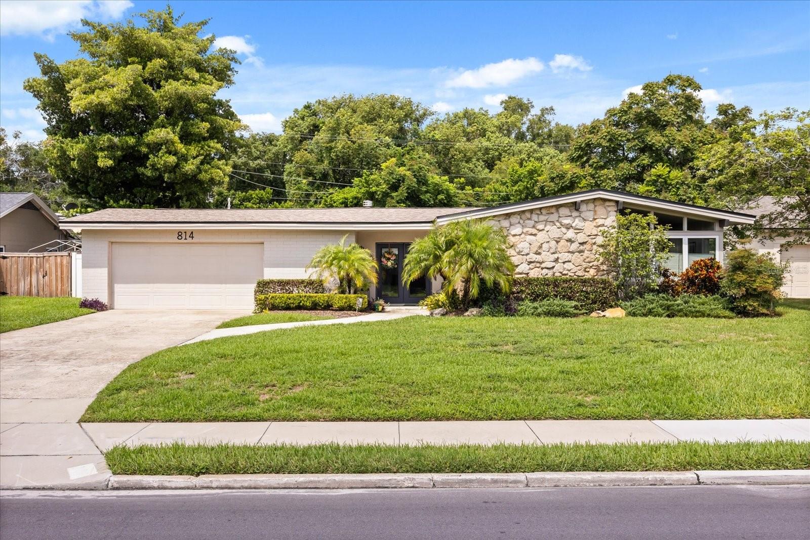 A mid century modern inspired ranch offers a special location just a block from the school with a walking path behind providing a unique lifestyle for this special home. Natural Coquina stone accents are the focal point of the exterior elevation with seamless windows that allow incredible light in and are in keeping with the architecture of the era. This 4-bedroom 2 bath home was thoughtfully renovated with vintage polished terrazzo, ceramic tile, some vaulted ceilings creating a spacious layout for ease of living. Kitchen is renovated with clean lined shaker cabinets, subway tile back splash, floating shelves, stainless appliances and sliding barn door for pantry. Kitchen blends with living space which can serve as dining or formal living, function possibilities are endless. Family spaces open through clear glass doors to back patio making entertaining a breeze with plenty of room to add on or grow. The 4th bedroom or home office is separate and off the family room while other 3 bedrooms are banked down another hallway. Bathrooms are fully updated with timeless appointments. A very spacious laundry room for great organization, provides easy day-to-day function. Other system updates include 2025 Lenox air conditioning, roof 2020, insulated garage door, vinyl fencing, irrigation system, vaulted ceilings and more. Situated in the heart of Dommerich this location allows you to enjoy an easy walk to schools, the “Quad” & close to the boardwalk to Maitland Community Park. Maitland is full of life home to terrific parks, fabulous restaurants, shopping, home to the Enzian Theatre, Lake Lily and more. This is a rare find.