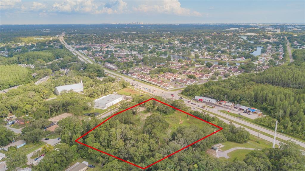 Prime Redevelopment Opportunity as this site is located within the Urban Service Area and within the limits of the Greater Carrollwood Northdale Community Plan. Rezoning needed for any use that is not single-family detached (conventional or mobile home). Per the County Planning Commission, the subject property is located within the Residential-9 (RES-9) Future Land Use category, which has a maximum density of 9 dwelling units per gross acre and a maximum intensity of 0.50 FAR. The RES-9 FLU designation would allow up to 40 dwelling units or 98,010 sq. ft. of non-residential. The subject site meets commercial locational criteria, and the nearest node is located at Nixon Road and Gunn Highway. The property is within the required 1,000 linear feet from the intersection node. The property is surrounded by single-family residential to the north, northwest, northeast, southwest and southeast. To the east is a pet resort, and religious institution. To the west is public institution land owned by Tampa Bay Water. To the south is a food truck plaza and a vacant land owned by Hillsborough County Public Schools. There are multi-family apartment communities and townhome communities within proximity to the site. A request for multi-family and townhome is not anticipated to have a compatibility issue next to the surrounding residential. Retail and office are considered non-residential uses and is subject to Commercial Locational Criteria per Future Land Use Policy 22.2. For these proposed uses, a detailed site plan is needed to address the potential impacts to the surrounding single-family residential. Furthermore, the site plan will need to address the following: access, buffers, screening, setbacks, height of buildings, sidewalks, etc. Placement of commercial buildings will need to be oriented and closer to Gunn Highway, to keep intense uses as far away as possible from residential. The proposed assisted living use could be a good use as the subject property is located along Gunn Highway which currently has Hart bus transportation. However, there is a lack of sidewalks. The Mobility Element Objective 2.2 encourages a Safe Systems Approach, which will require enhanced sidewalks with crosswalk improvements.
Zoning Staff Comments: The RES-9 future land use category will possibly permit a maximum of 40 units (if wetlands do not exceed 25% of the site) if proposing townhome or apartments. Project will need to demonstrate compatibility with adjacent residential uses (building height, building placement, screening, ect). The RES-9 future land use category will possibly permit a maximum floor area ratio of 0.50 (97,792 sf) (if wetlands do not exceed 25% of the site) if proposing retail or office. The project will need to meet the commercial locational criteria policies of the Comprehensive Plan. Project will need to demonstrate compatibility with adjacent residential uses (building height, specific use, building placement, etc). The RES-9 future land use category will possibly permit a maximum of 200-beds for an assisted living facility. Project will need to comply with LDC Section 6.11.28 (https://library.municode.com/fl/hillsborough_county/codes/land_development_code?
nodeId=ARTVIDESTIMRE_PT6.11.00SPCOUS_S6.11.28COREHO) which requires distances from RSC zonings and any other licensed homes.
Gunn Highway is an Urban Scenic Corridor (tree plantings required/no buffer)
