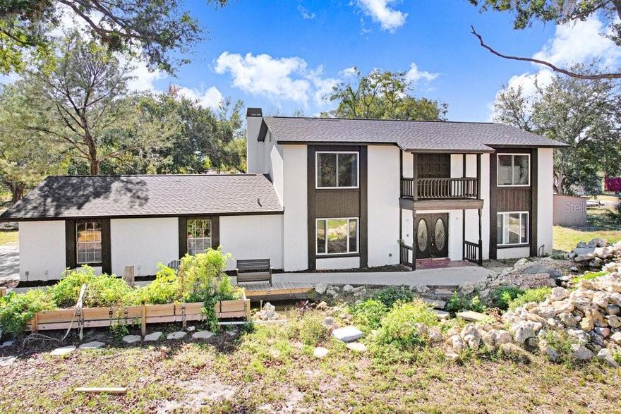 Nestled in the highly desirable Odessa area, this farm pool house sits on two parcels totaling 5.77 acres, complete with a serene pond at the rear and a wealth of potential. The partially updated 3-bedroom, 3-bathroom home spans 2,372 square feet and awaits its new owner to finish the transformation into a dream retreat. The first floor offers a formal living room, formal dining room, a well-appointed kitchen with quartz countertops, stainless steel appliances, and ample storage, conveniently situated between the dining room and the spacious family room. The oversized family room features a wood-burning fireplace and French doors opening to a screened-in pool, perfect for entertaining or tranquil evenings. Upstairs hosts the master suite with an office/bonus room and an en suite bath featuring his-and-her sinks and a stand-alone shower. Two additional guest bedrooms and a guest bathroom complete the upper level. An attached two-car garage adds convenience, while the outdoor oasis showcases a koi pond with a waterfall, wooden decking for seating, and a screened-in pool set against expansive land. Additional outbuildings include a two-car carport and extra storage sheds. Notably, the home sits on one parcel, with the second parcel offering potential for another residence or the possibility of selling it separately. Conveniently located near the Veterans Expressway, this property provides easy access to all of Tampa, making it an ideal canvas for a buyer seeking space, privacy, and future