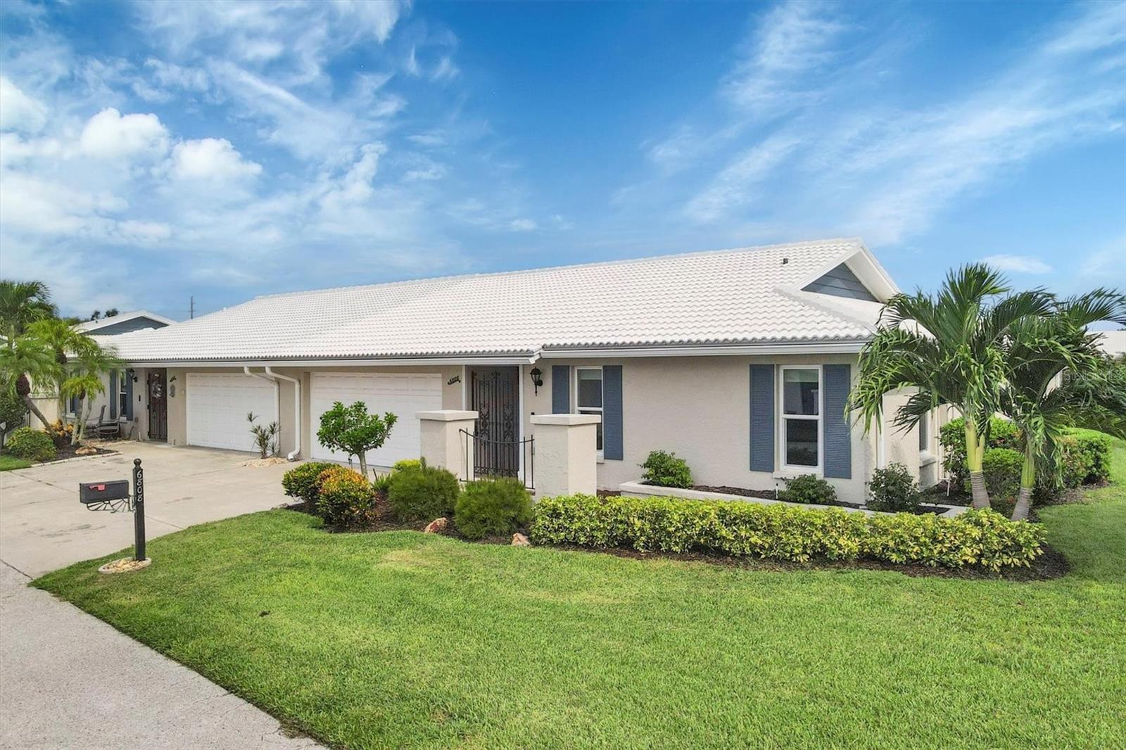 Embrace the Florida lifestyle with this ever-popular 55+ Village Green paired villa on a quiet cul-de-sac and located in far west Bradenton only 5.7 miles to beautiful Holmes Beach on Anna Maria Island. This most popular D model floor plan offers 1803 sq ft of air-conditioned space and includes an exterior 16 x 14 screened paver deck area overlooking a greenbelt, suitable for relaxation and entertaining. This outdoor patio area is referred to as “the bird cage.” This floor plan comes with an oversized 2 car garage with a wind resistant door on remote. As a bonus, tile roof replaced in 2018, A/C and electric service panel new in 2022, all at the owner's expense. For safety reasons hurricane impact wind resistant insulated windows protect the interior. Upon entry, the unit features a secure steel gate and a roll-down hurricane shutter. A ceramic tiled foyer with two large closets, new carpet in the bedrooms, dining room and living room all having crown molding and upgraded window treatments. Double pane insulated French doors open to the Florida room and also access the outside birdcage from the family room. The galley kitchen features a serving pass through to the dining room, granite counter tops, a stainless-steel double sink, refaced cabinets with draw and pantry pull outs, recessed lighting, a new garbage disposal 2022 and a new dishwasher at the end of 2024. Both bedrooms are spacious and include large closets. The primary bedroom suite offers a spacious walk-in shower. Both bathrooms partially updated. The laundry room includes a full-size washer and dryer, a utility sink, overhead cabinets for storage, and extra space that can be used for additional appliances or repurposed as a craft area or office. The land owned condo fee only $350 a month and paid $1,050 quarterly covers basic cable TV, internet, exterior painting, annual roof cleaning, common area taxes, community pool, escrow reserves, grounds maintenance, landscaping (excluding the patio area behind the front pillars), exterior pest control, and pool upkeep. This location provides quick access to shopping centers, medical facilities, unlimited restaurants, GT Bray Park, Robinsons Preserve, Downtown Riverwalk, and the Gulf Beaches. The nearest airports are SRQ, TPA and PIE. For your own personal private showing secure your appointment with the listing agent today.